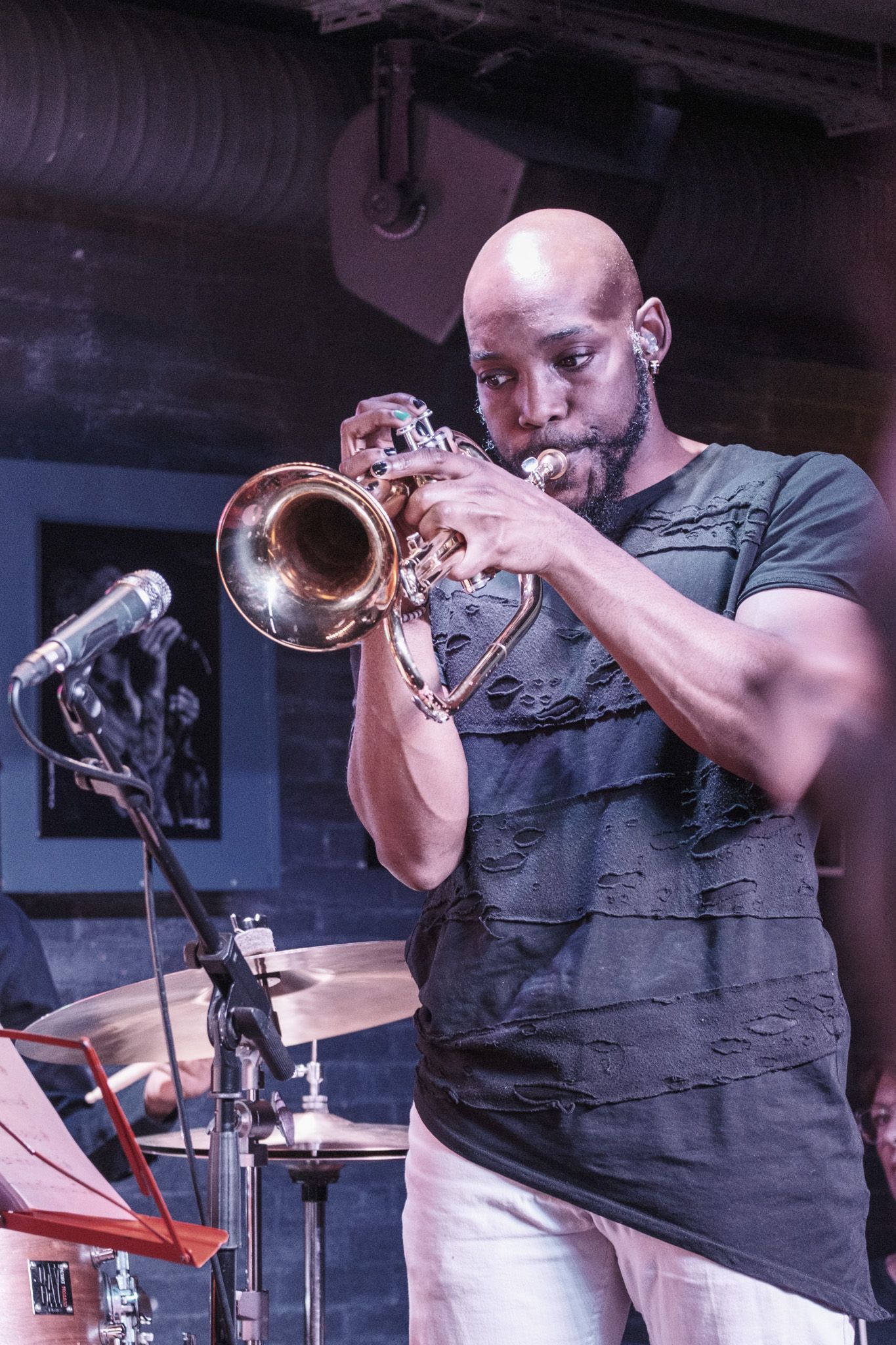 Musician performing with trumpet on stage during a jazz performance.