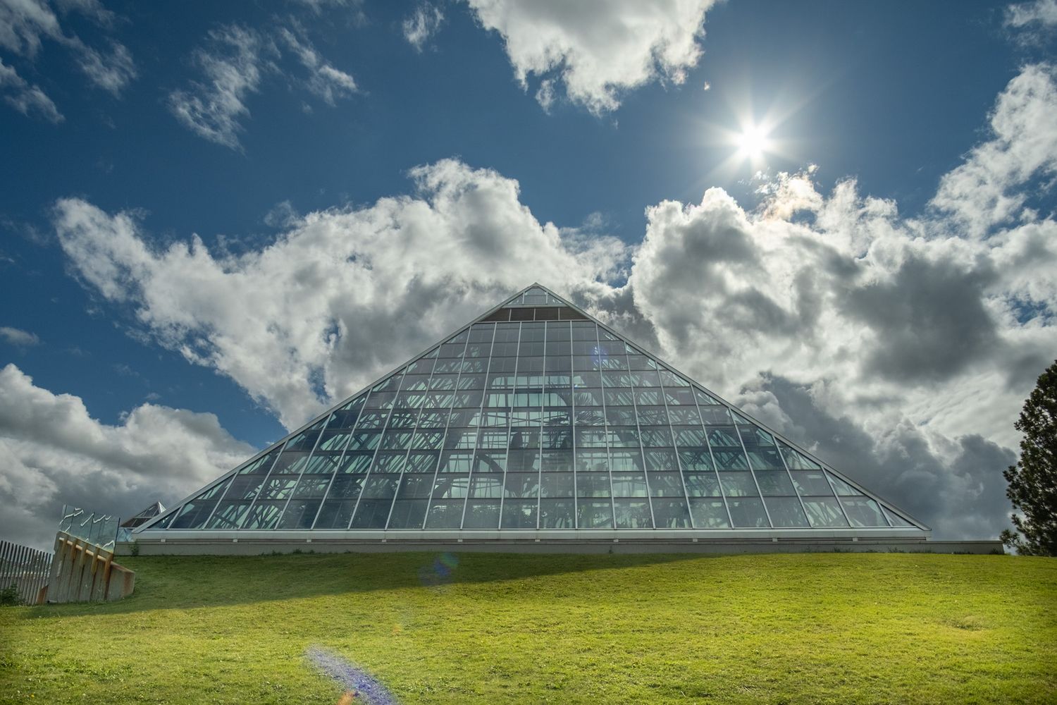 Pyramid of glass with the sun in the background.
