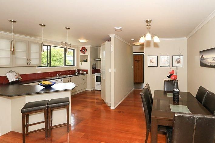 Open concept kitchen and dining space with polished wood floors and contemporary fixtures.