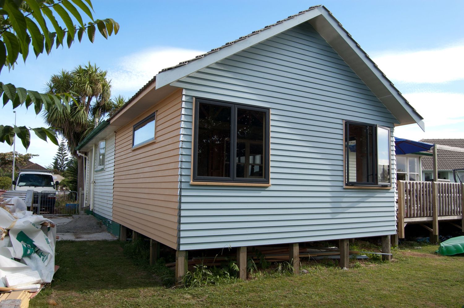 White weatherboard house exterior with green trim viewed from different angles.