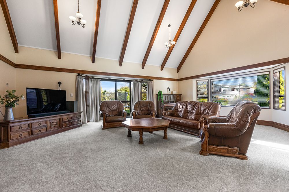 Large open concept living area with exposed ceiling beams and panoramic windows.