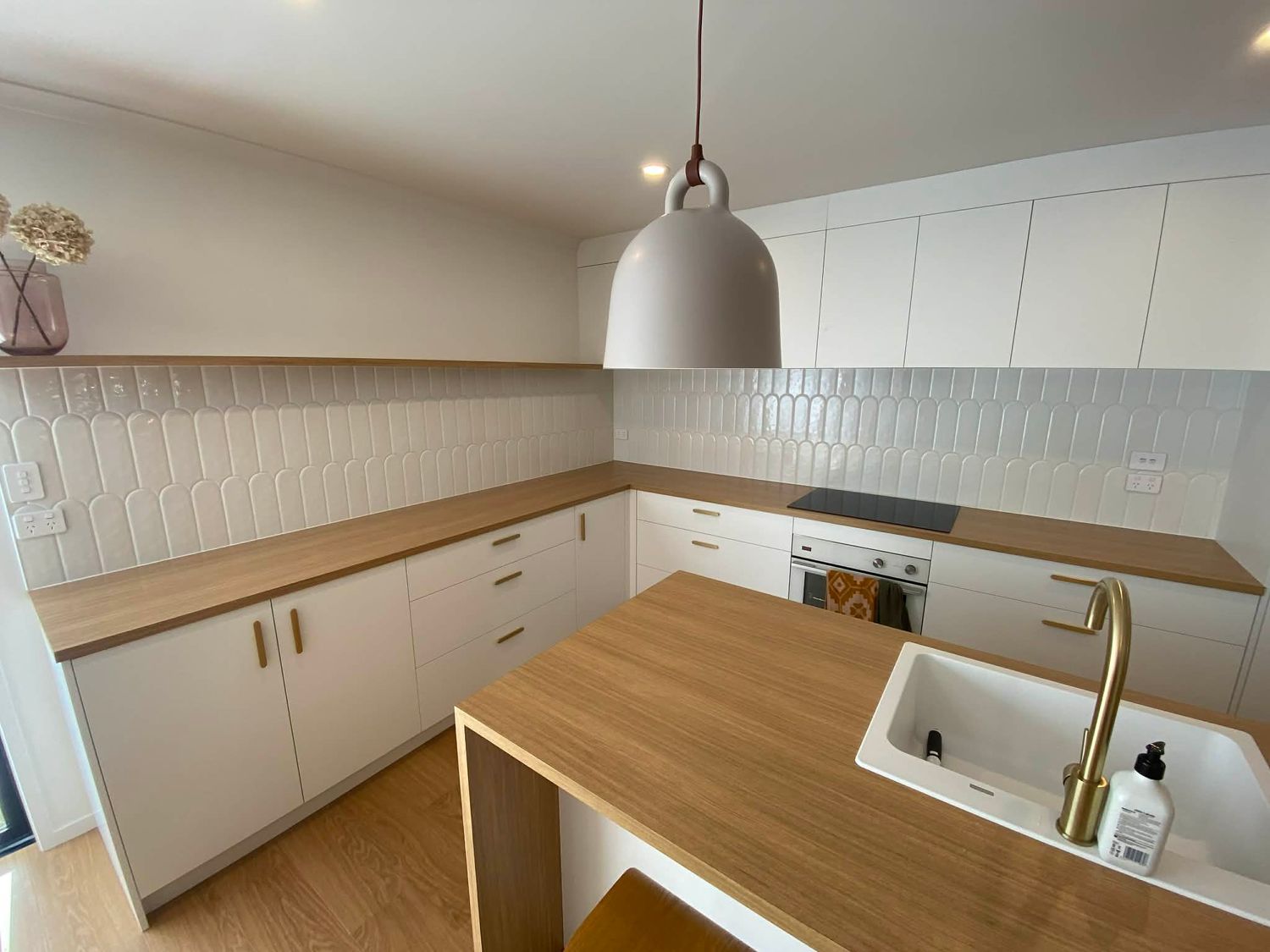 Modern kitchen interior with wooden countertops and white shiplap walls.