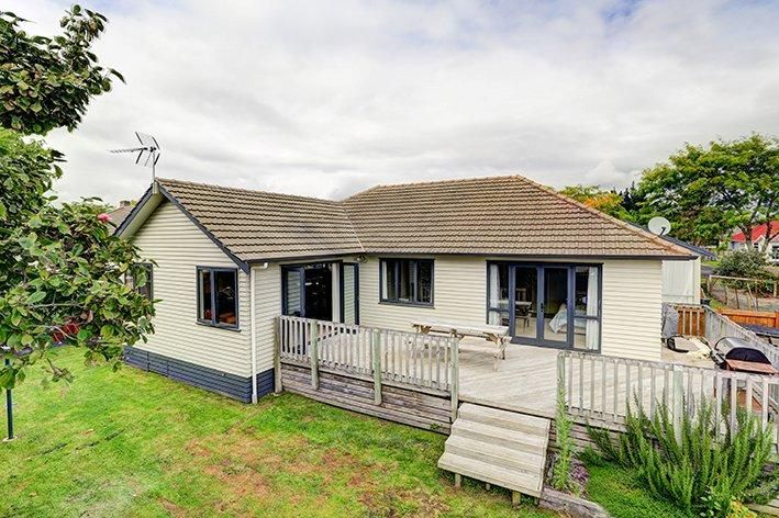 White single-story house with deck and landscaping shown from multiple exterior angles.