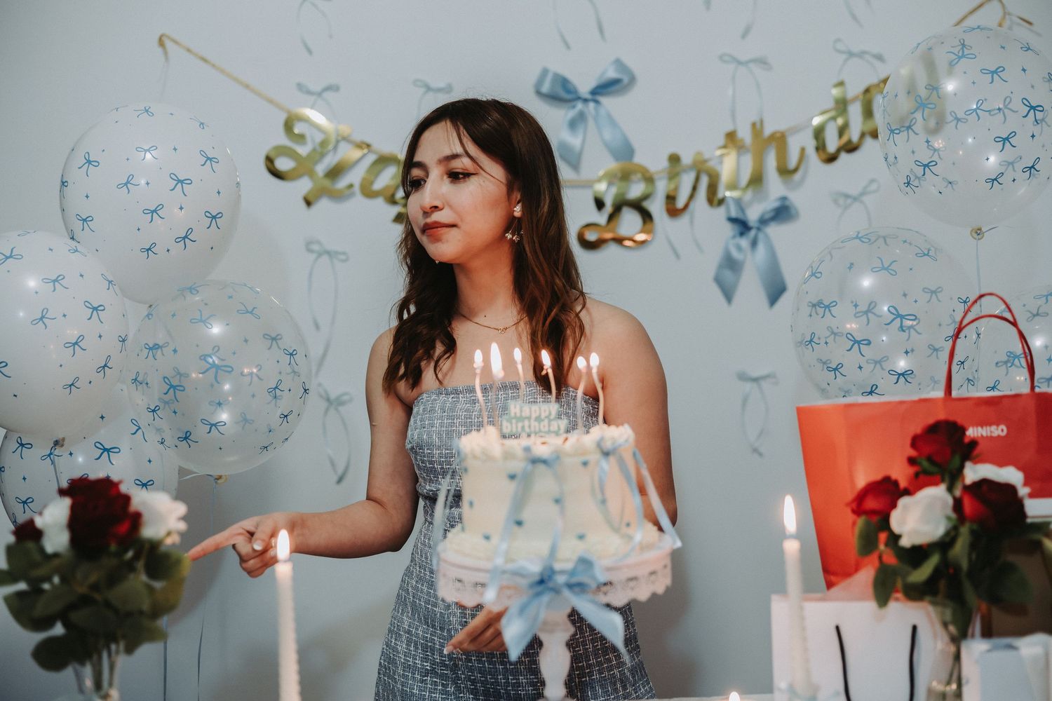 Birthday celebration with sheer balloons, decorative bows and gold lettering banner.