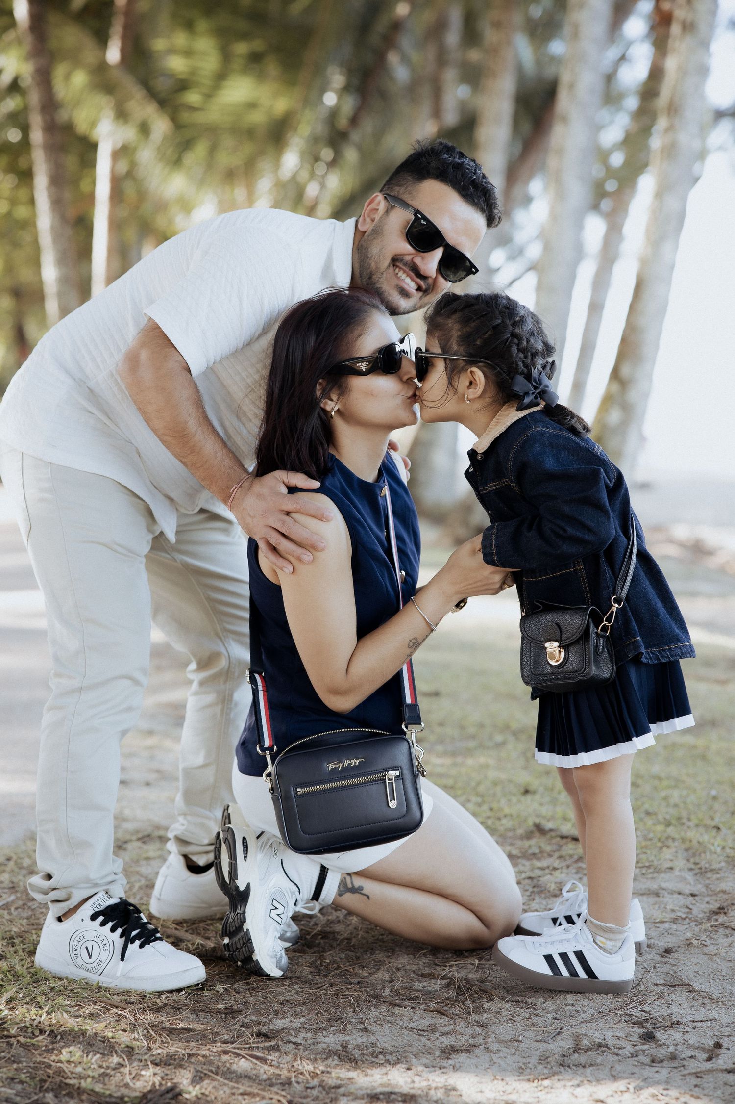 A tender family moment captured outdoors with matching white and navy outfits.