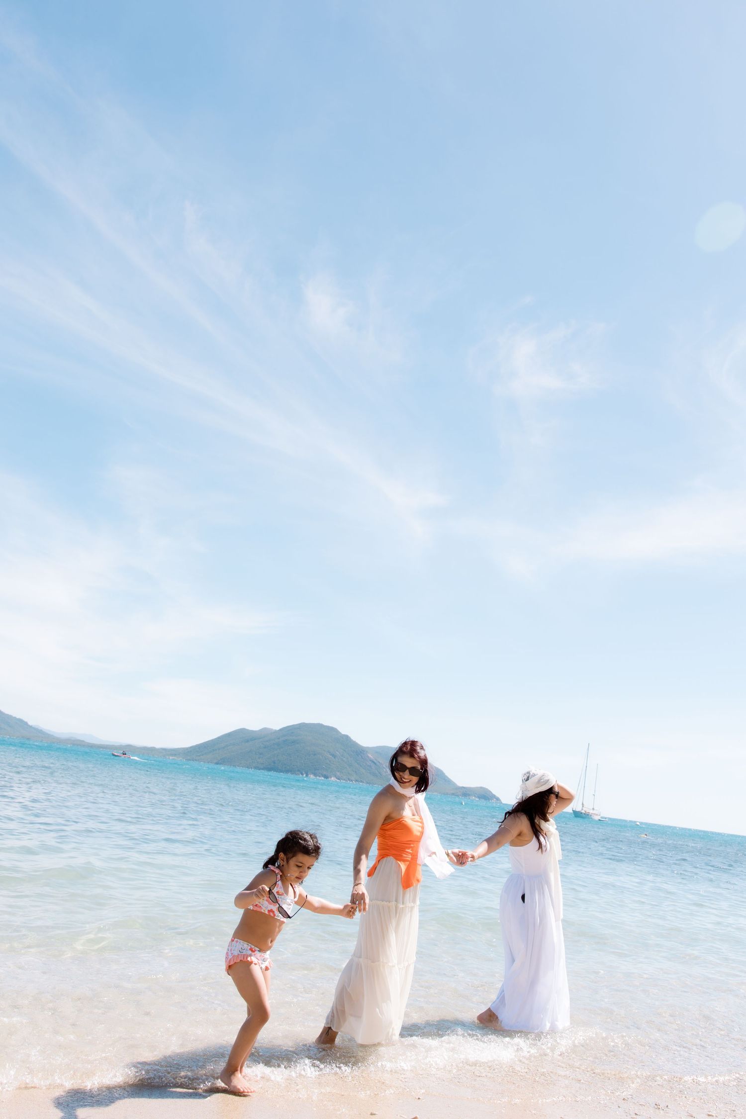 Playful couple splashing in crystal clear ocean waters at a tropical beach.
