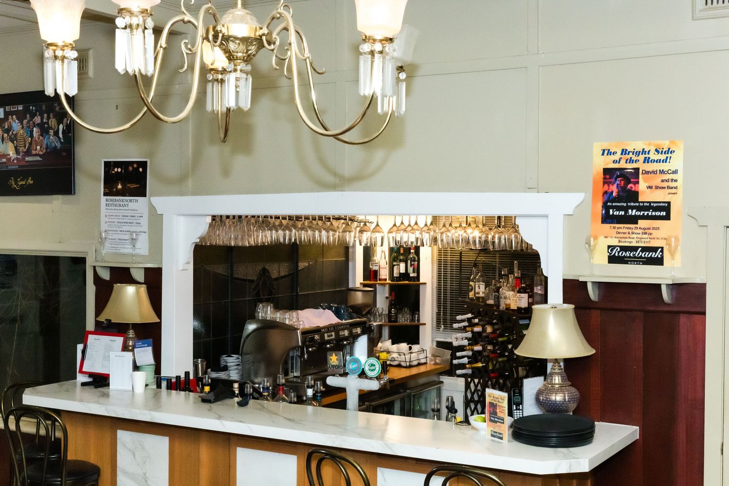 Interior view of a restaurant counter with chandelier and vintage decor.