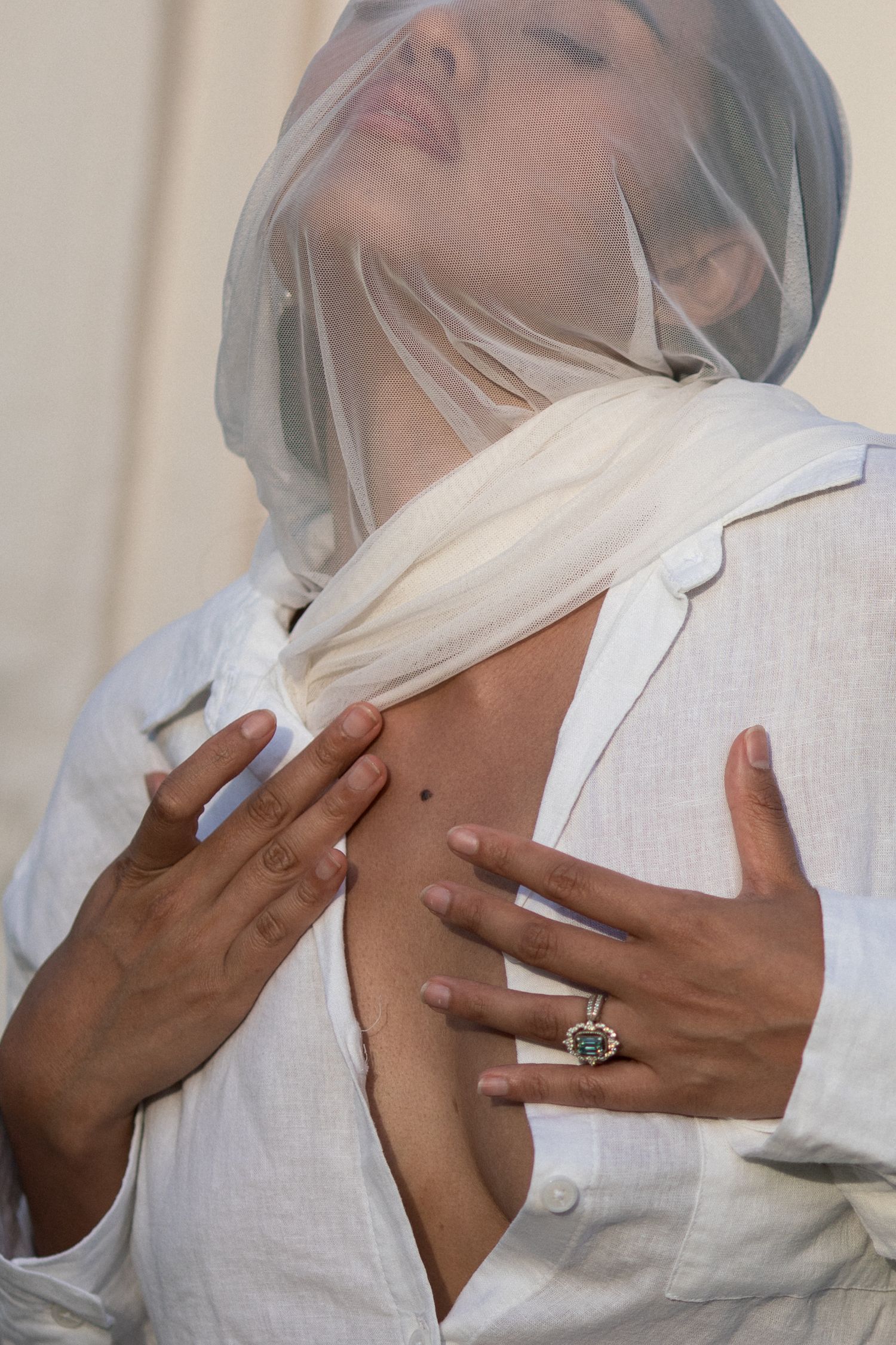 A series of artistic black and white photographs showing hands delicately touching a white fabric veil.