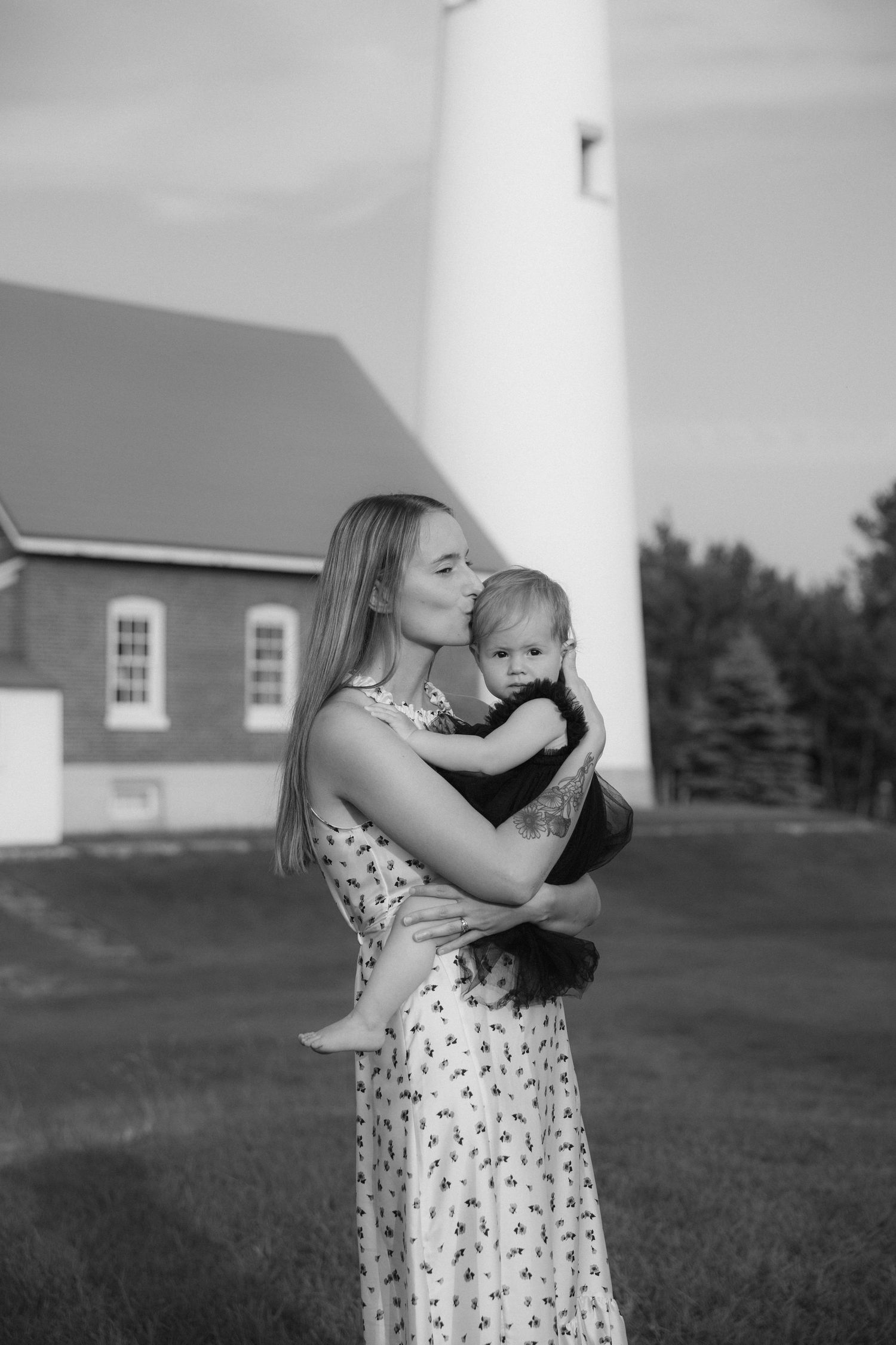 Sequential shots of lighthouse with building in background on grassy hill.