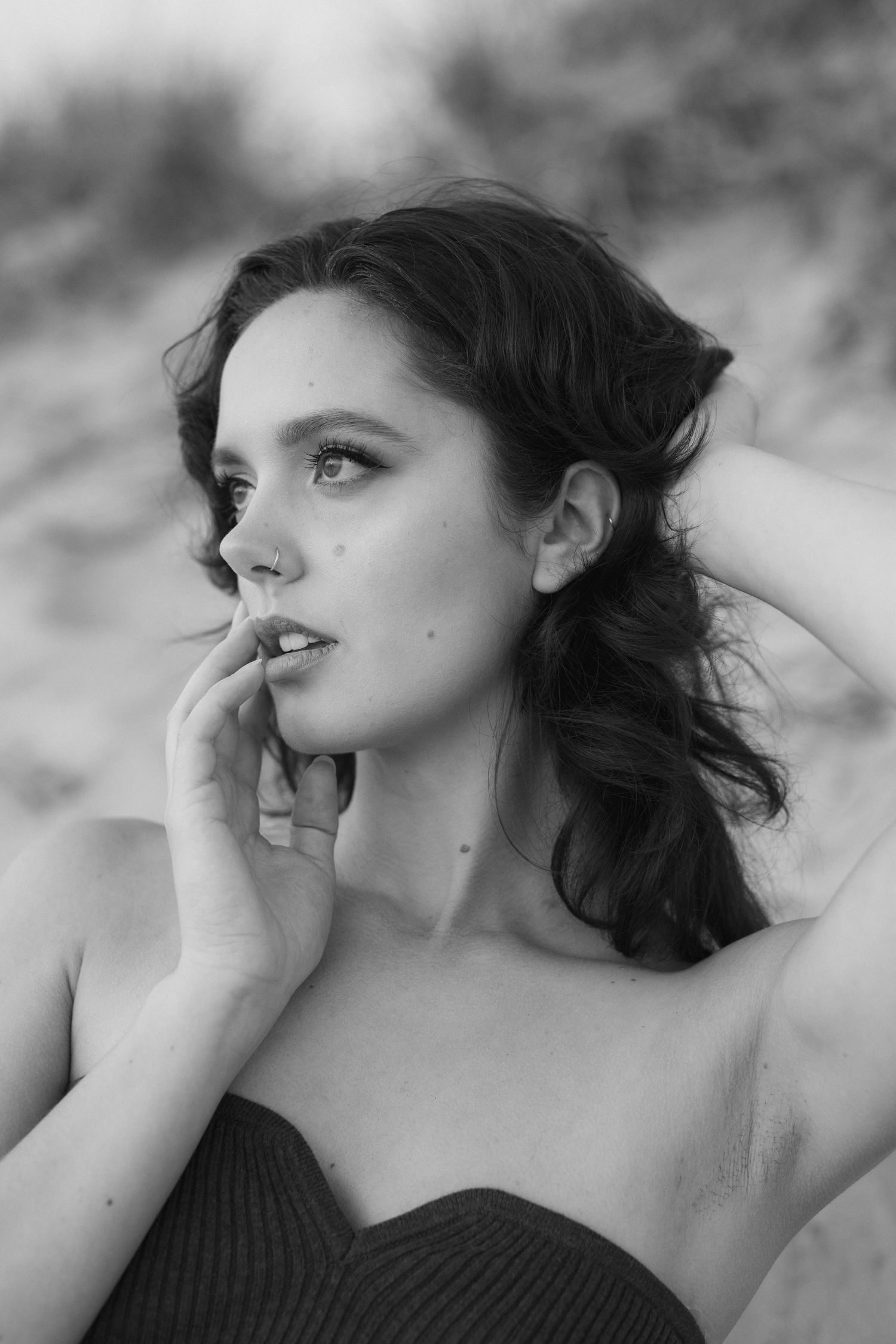 Artistic black and white portrait series showing dramatic side profile poses with flowing dark hair against soft lighting.