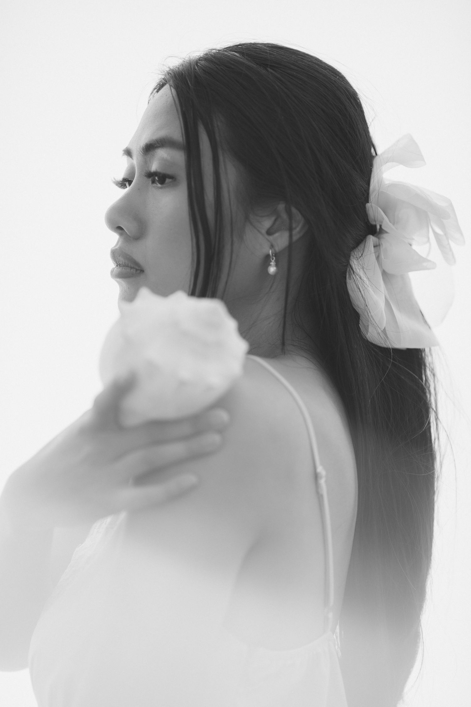 A series of artistic black and white profile portraits showing a figure wrapped in ethereal white fabric against a light background.