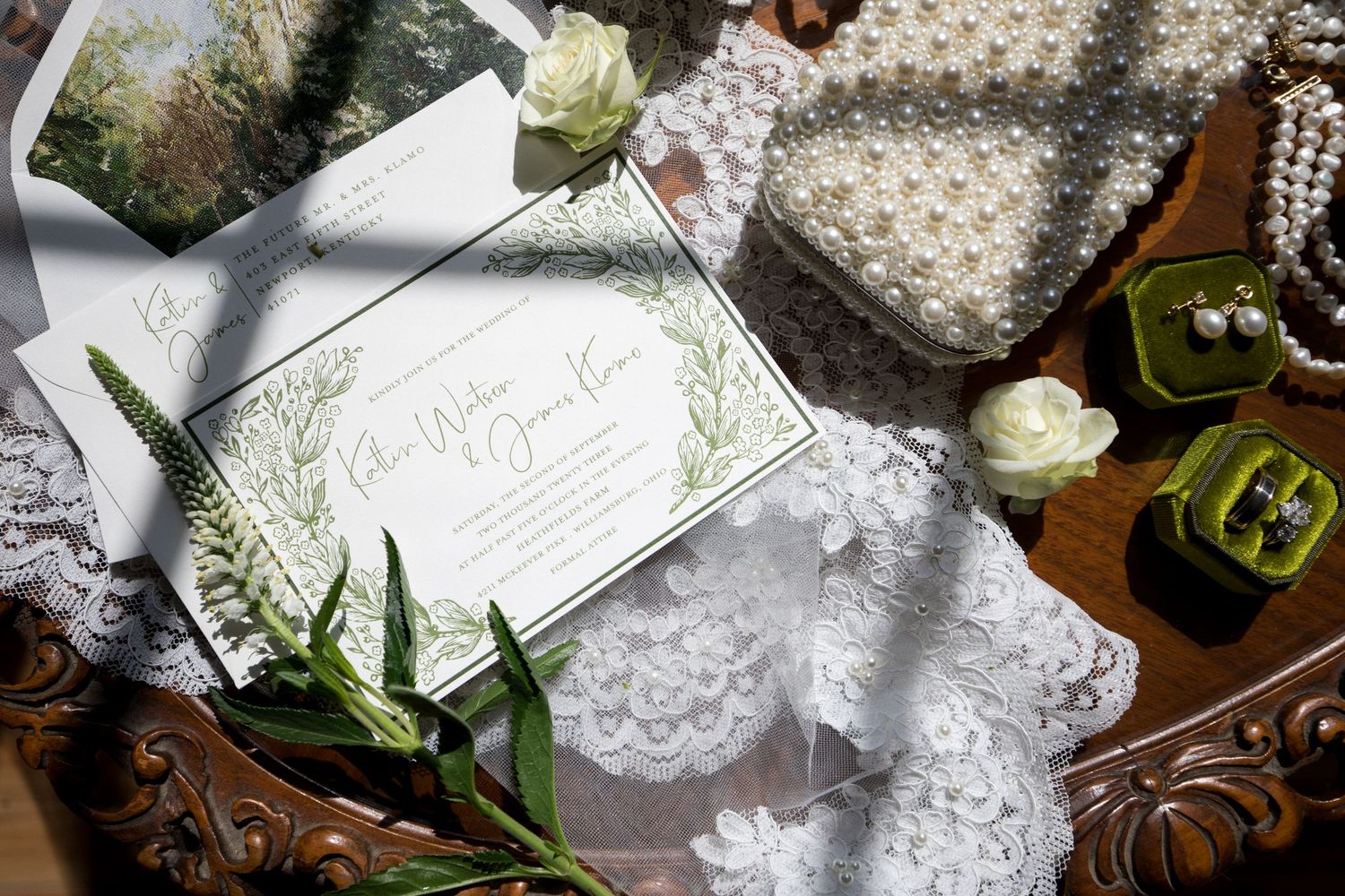 Vintage lace wedding decor elements including white doilies, ribbons, and delicate floral arrangements on a wooden surface.