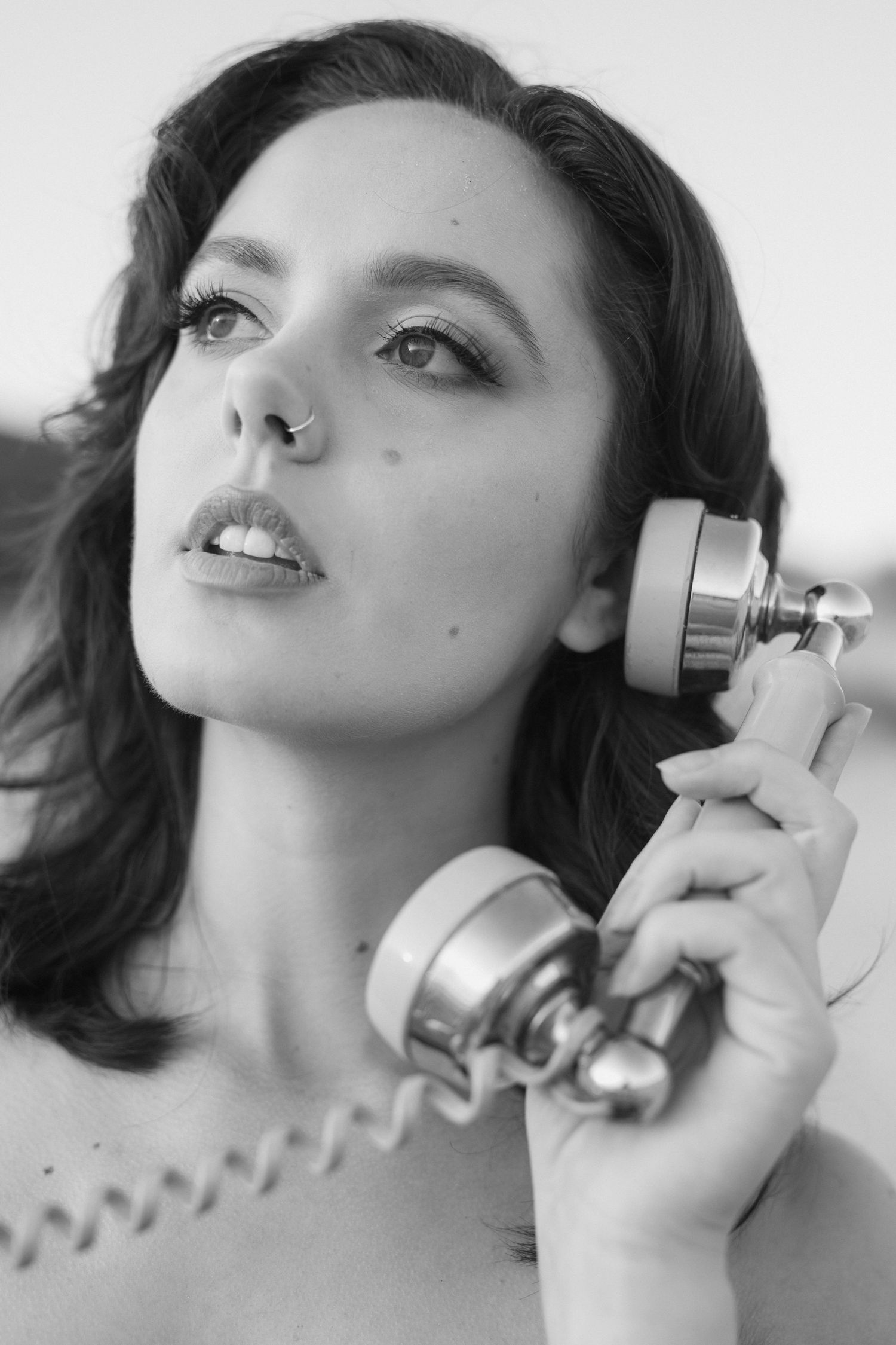 A black and white fashion photo series showing a person posing with a perfume bottle in artistic close-up shots.