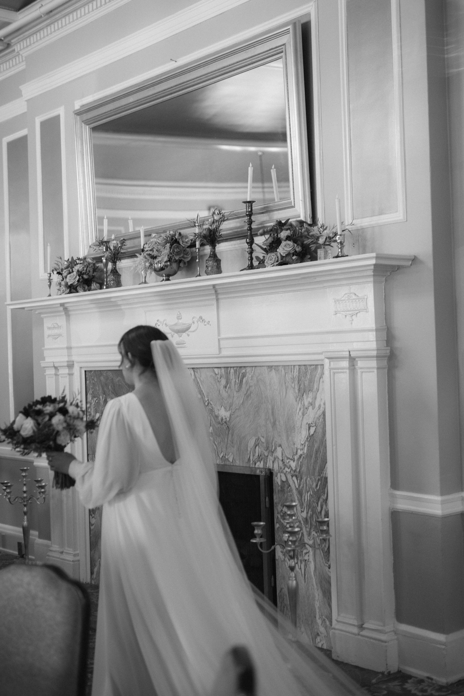 A black and white panoramic sequence showing ghostly figures in white veils moving through an ornate hallway.