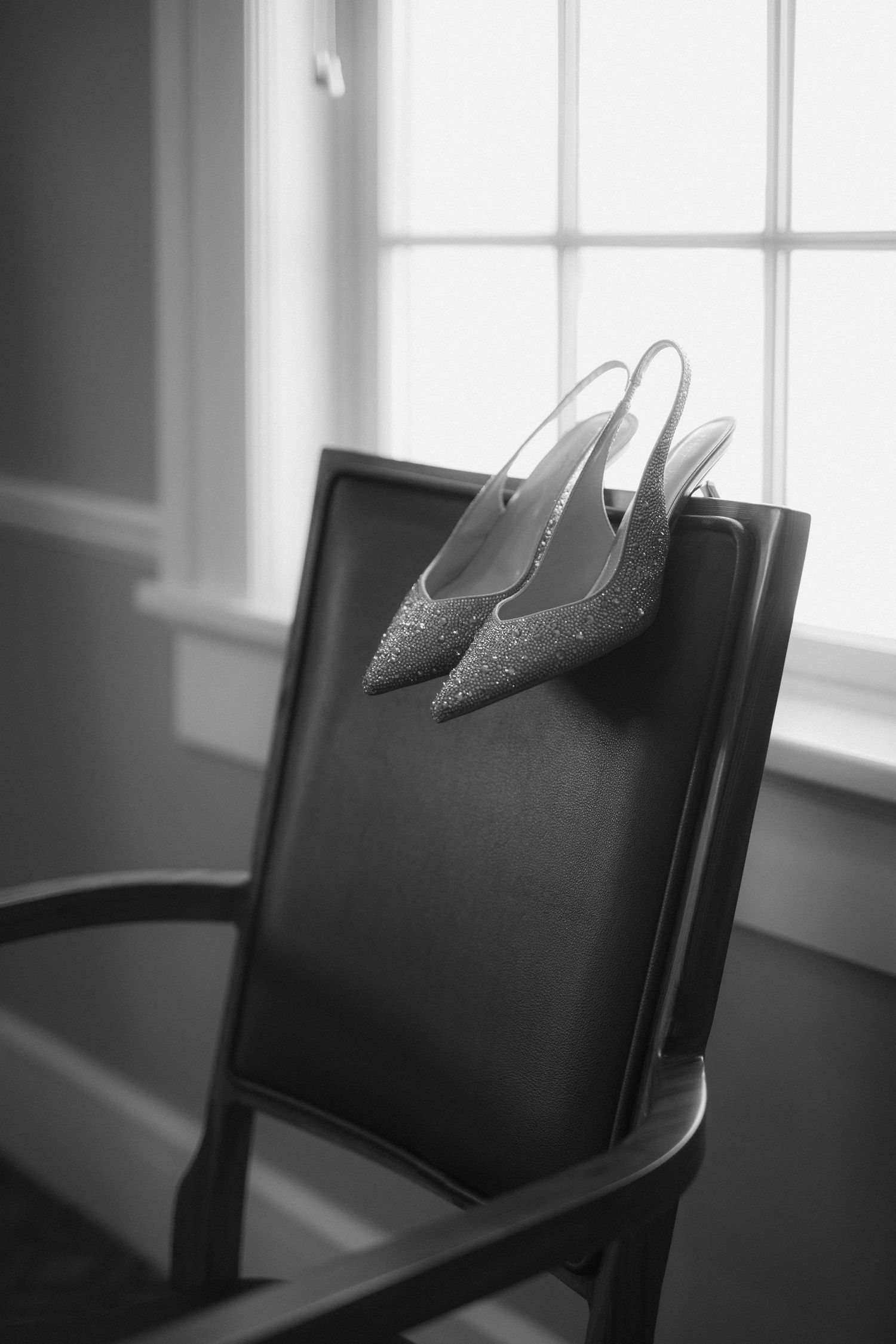 A series of black and white photographs showing empty chairs against a window in varying compositions.