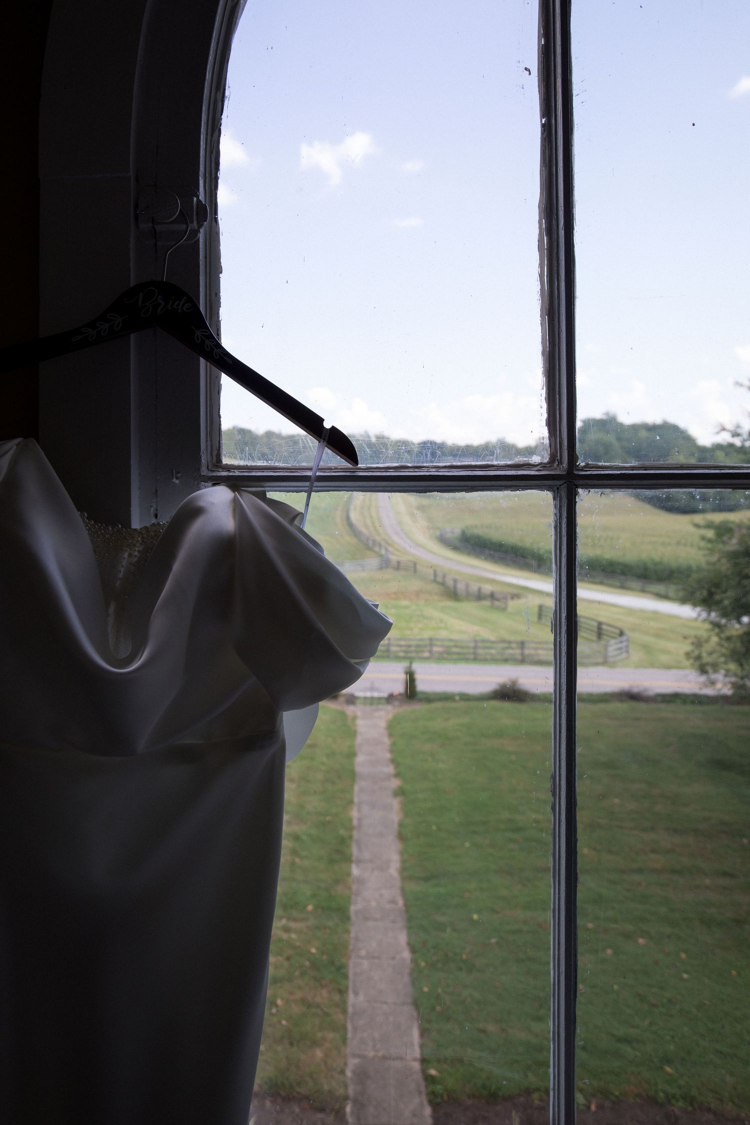 A series of window views showing a winding dirt path through grassy fields leading to the horizon.
