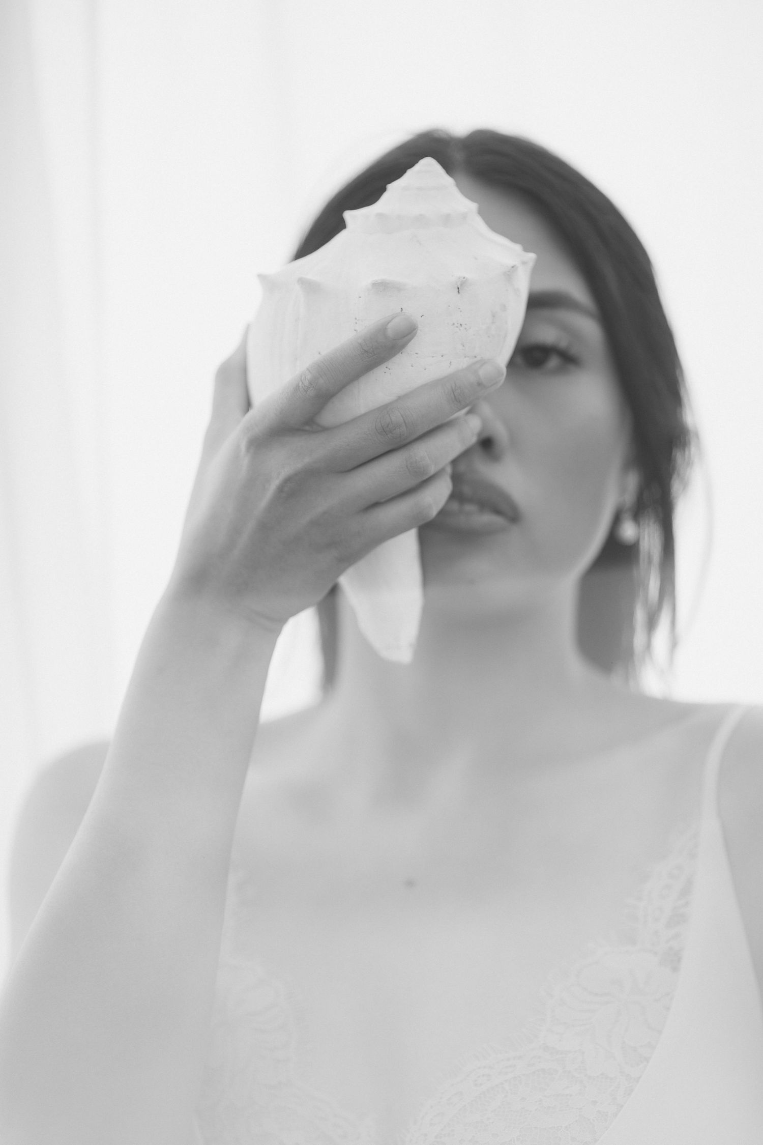 A black and white artistic photo series showing someone wiping their face with tissues in three sequential shots.