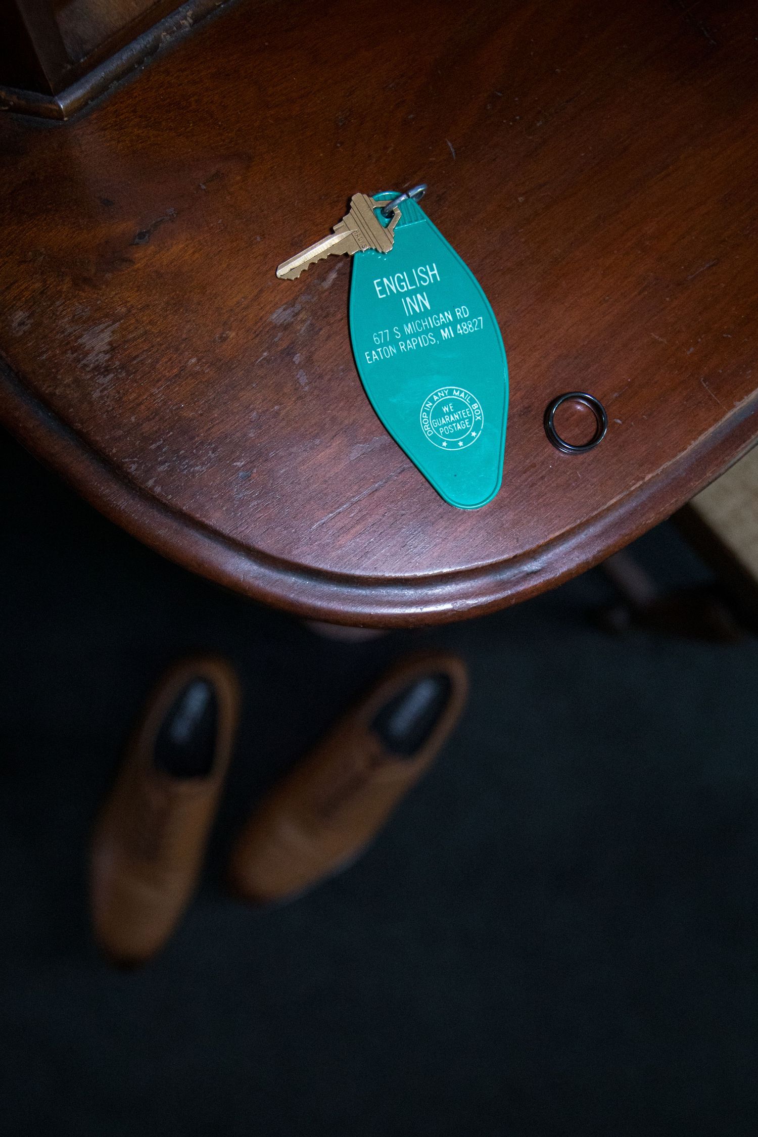 Close-up view of a turquoise tag attached to a dark wooden violin body in low light conditions.