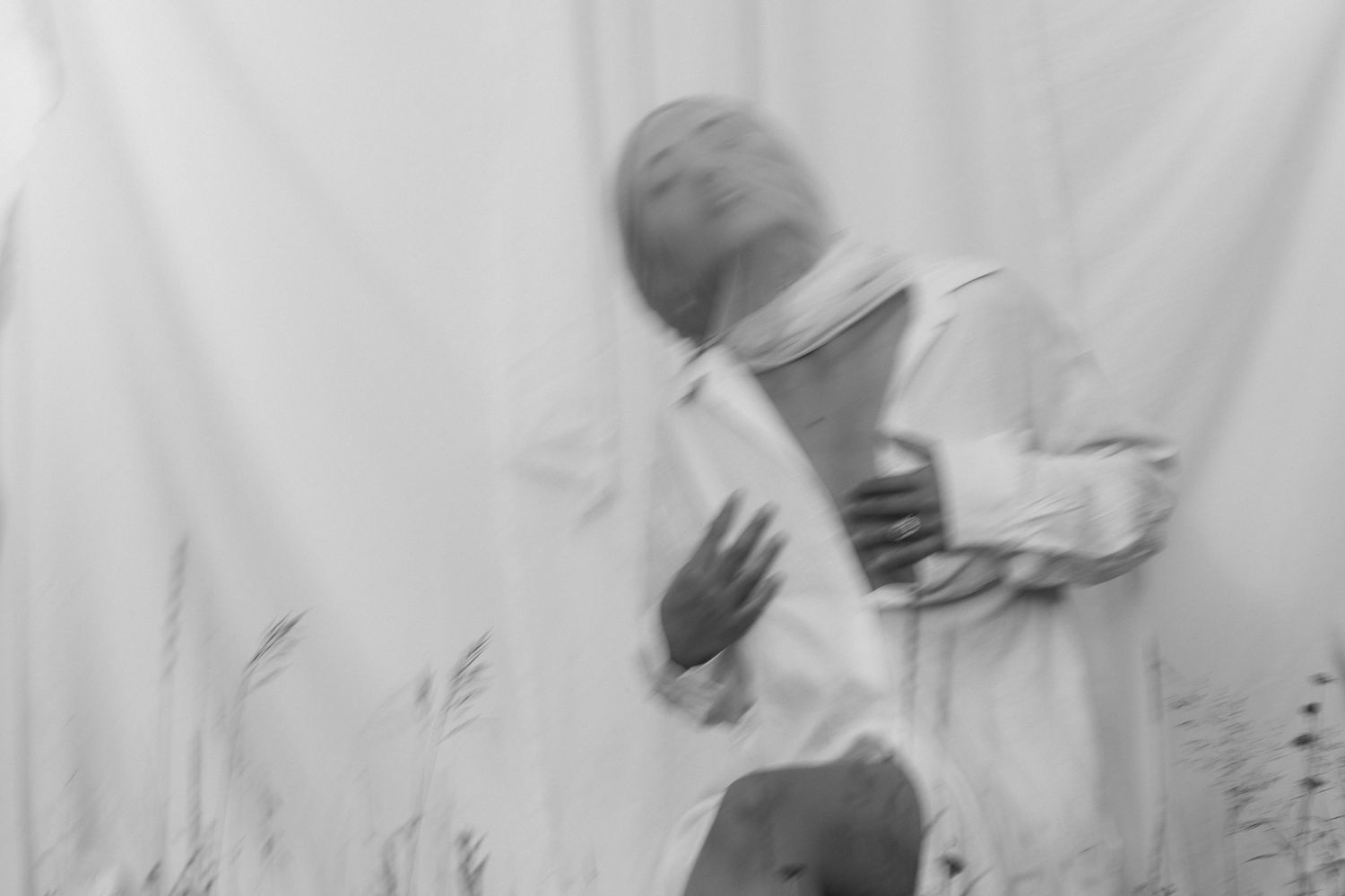 People in white lab coats and protective gear work in a clean laboratory environment.