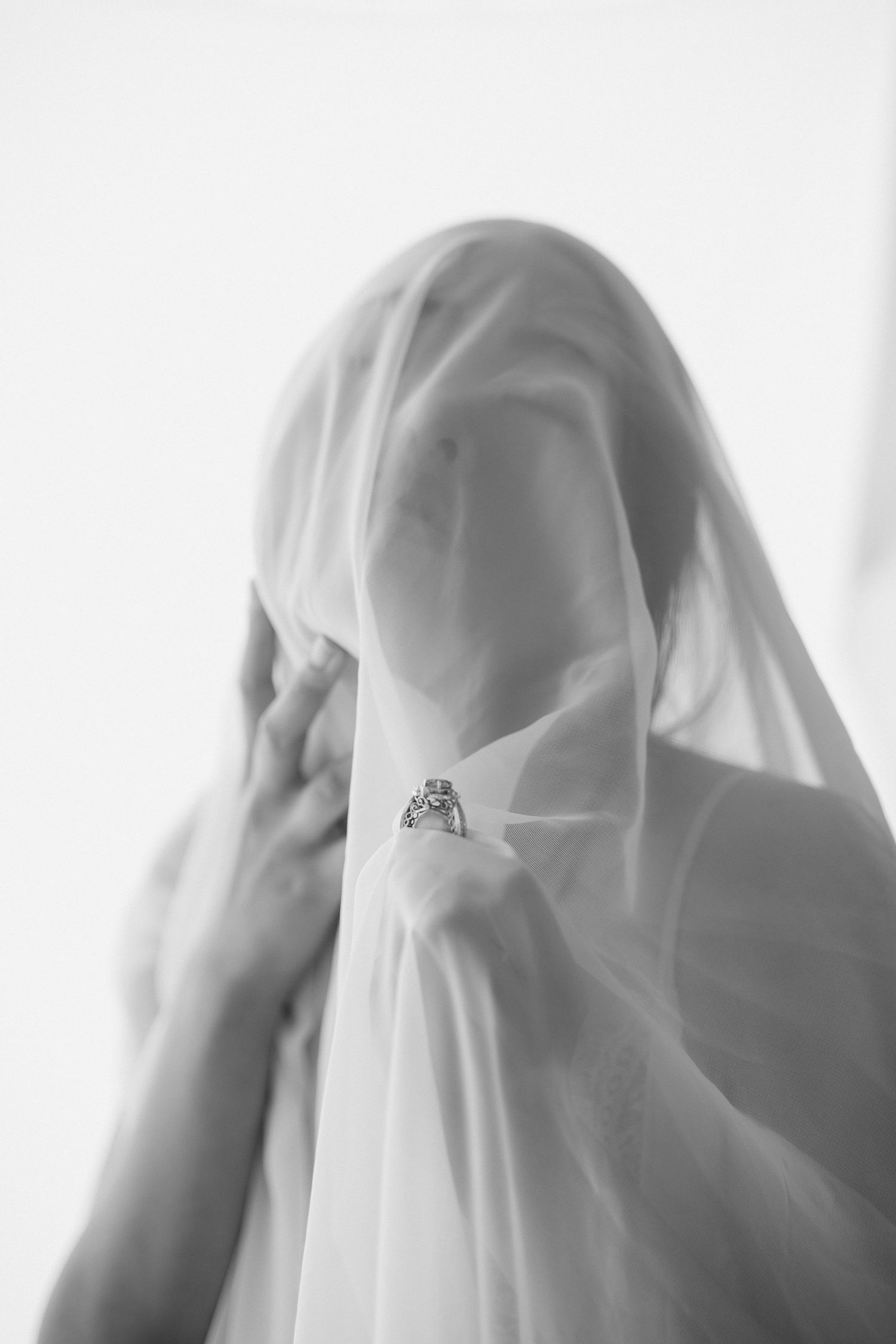 Black and white artistic photo sequence showing a figure covered in translucent fabric creating an ethereal effect.
