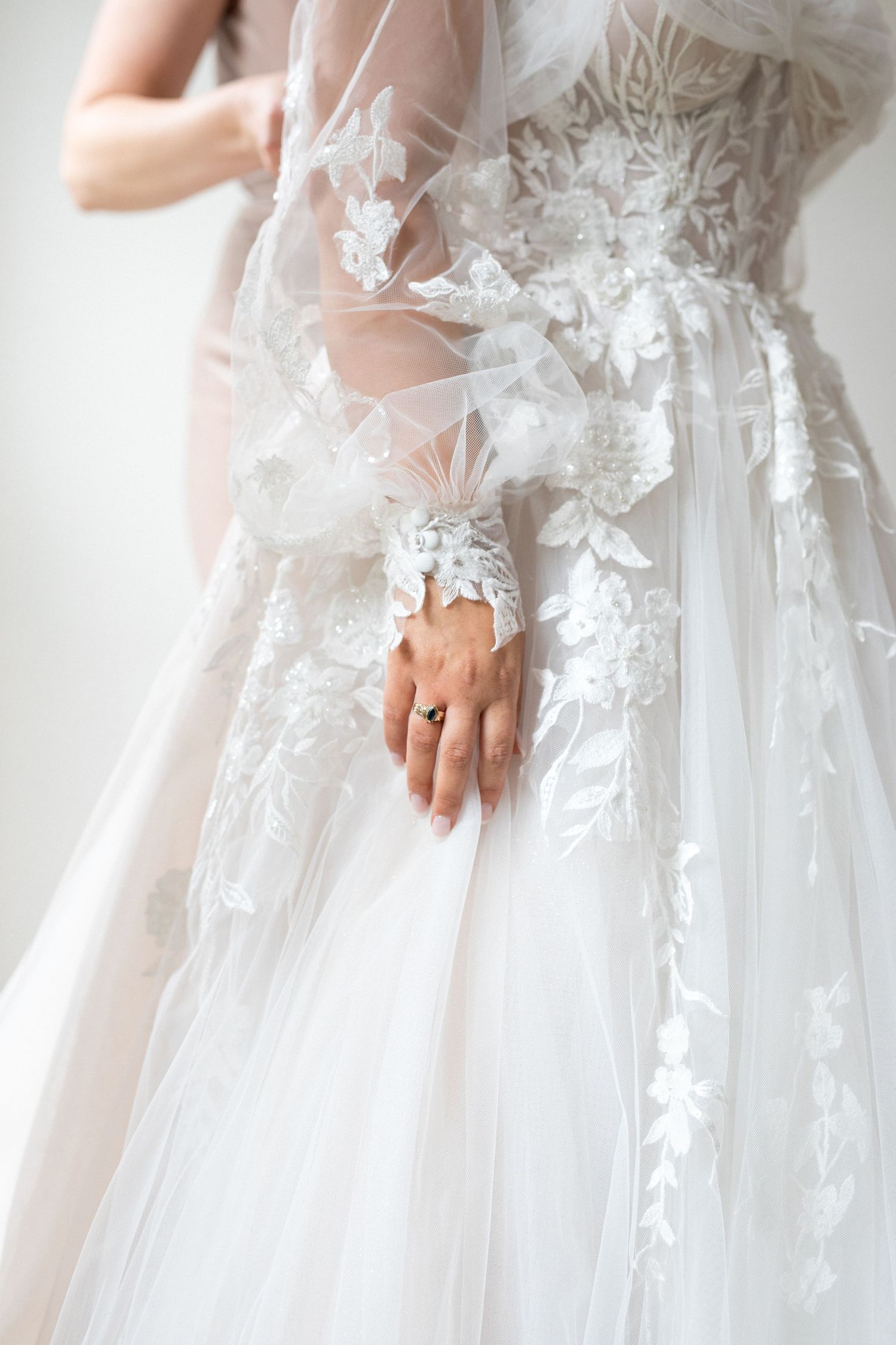 Close-up details of delicate white lace and tulle on an elegant wedding dress.