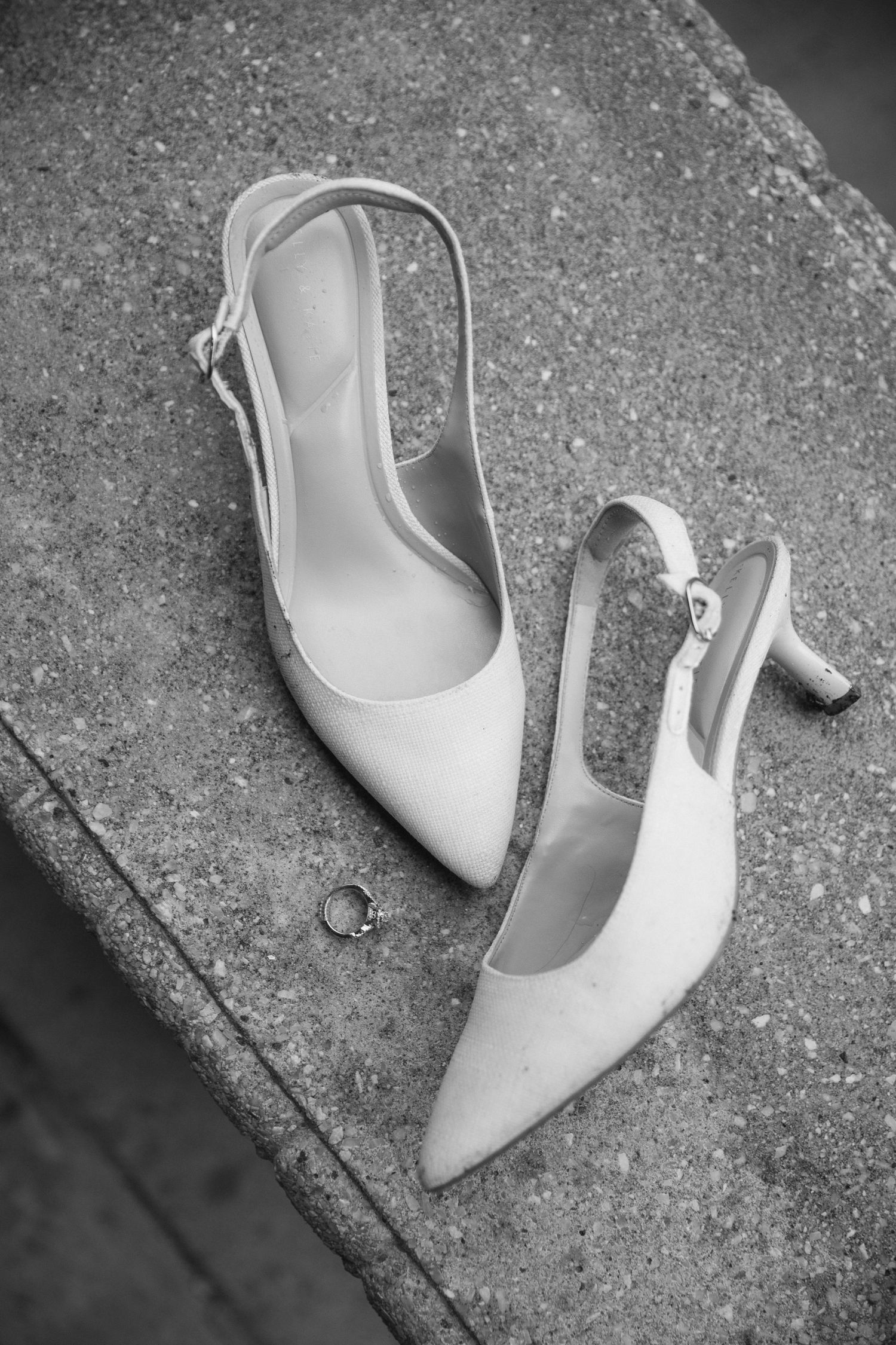 A sequence of black and white photos showing a white slingback high heel shoe from different angles on concrete ground.