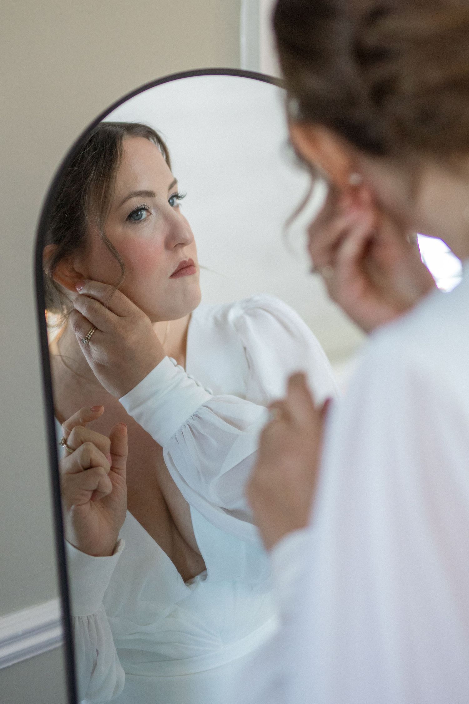 Two figures in white garments share an intimate moment in a series of artistic portrait photographs.