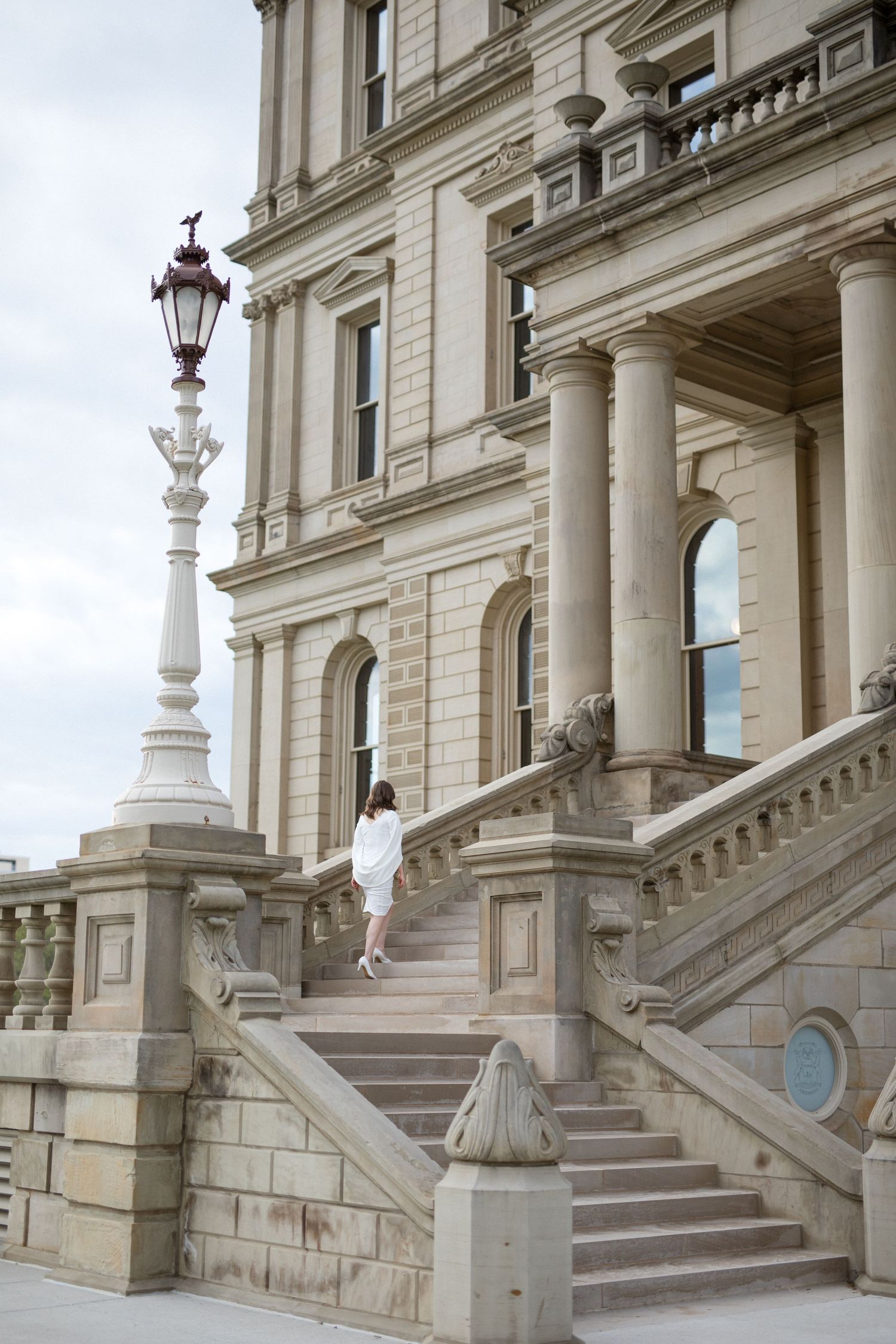 A grand stone staircase with ornate balusters and columns at a historic building entrance.