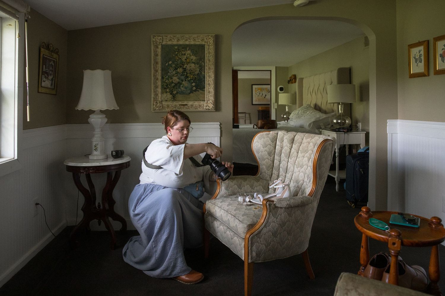 Person in white shirt cleaning a light colored couch with professional upholstery cleaning equipment.