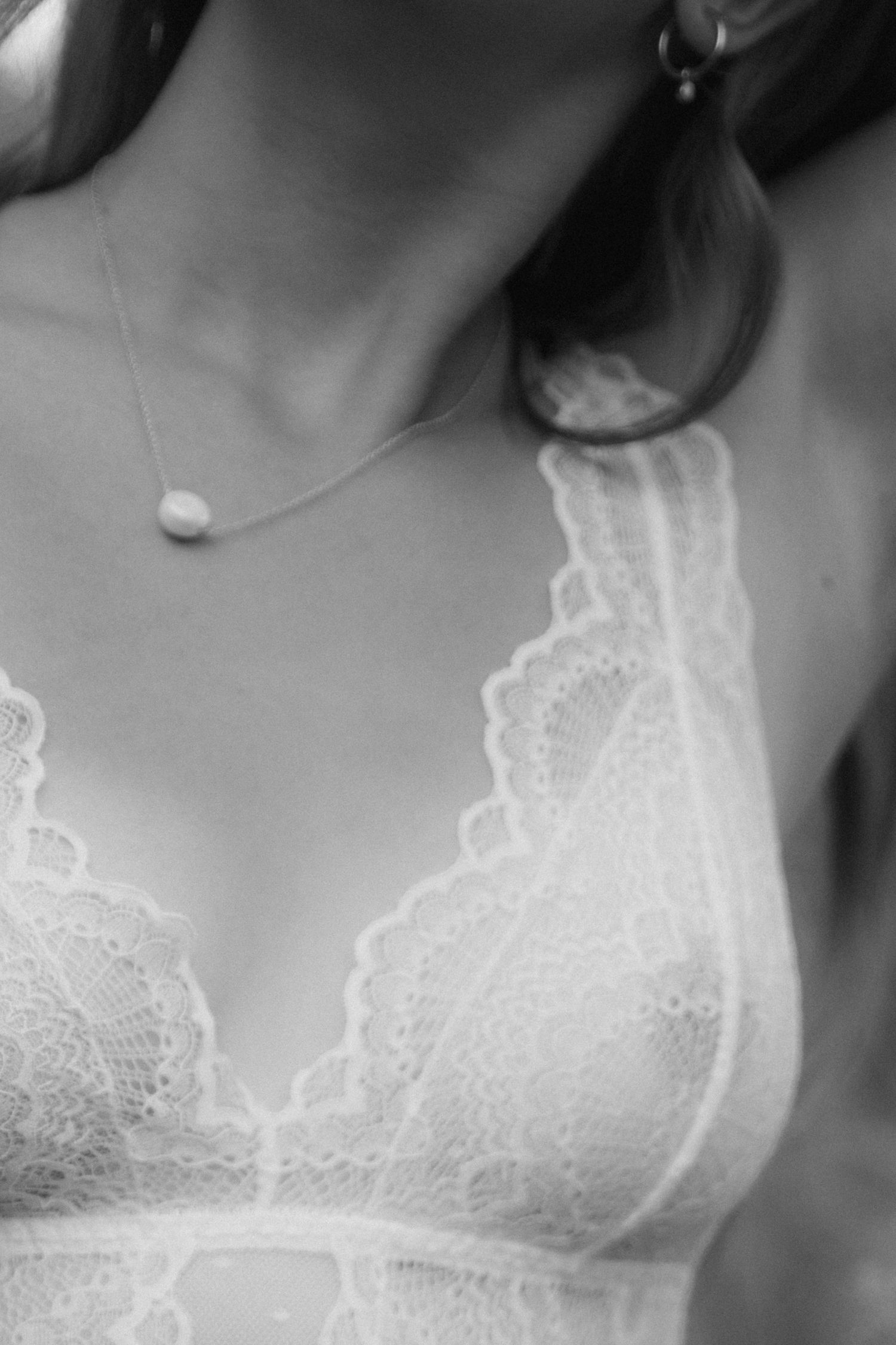 Black and white close-up sequence showing delicate white lace details on clothing against a dark background.