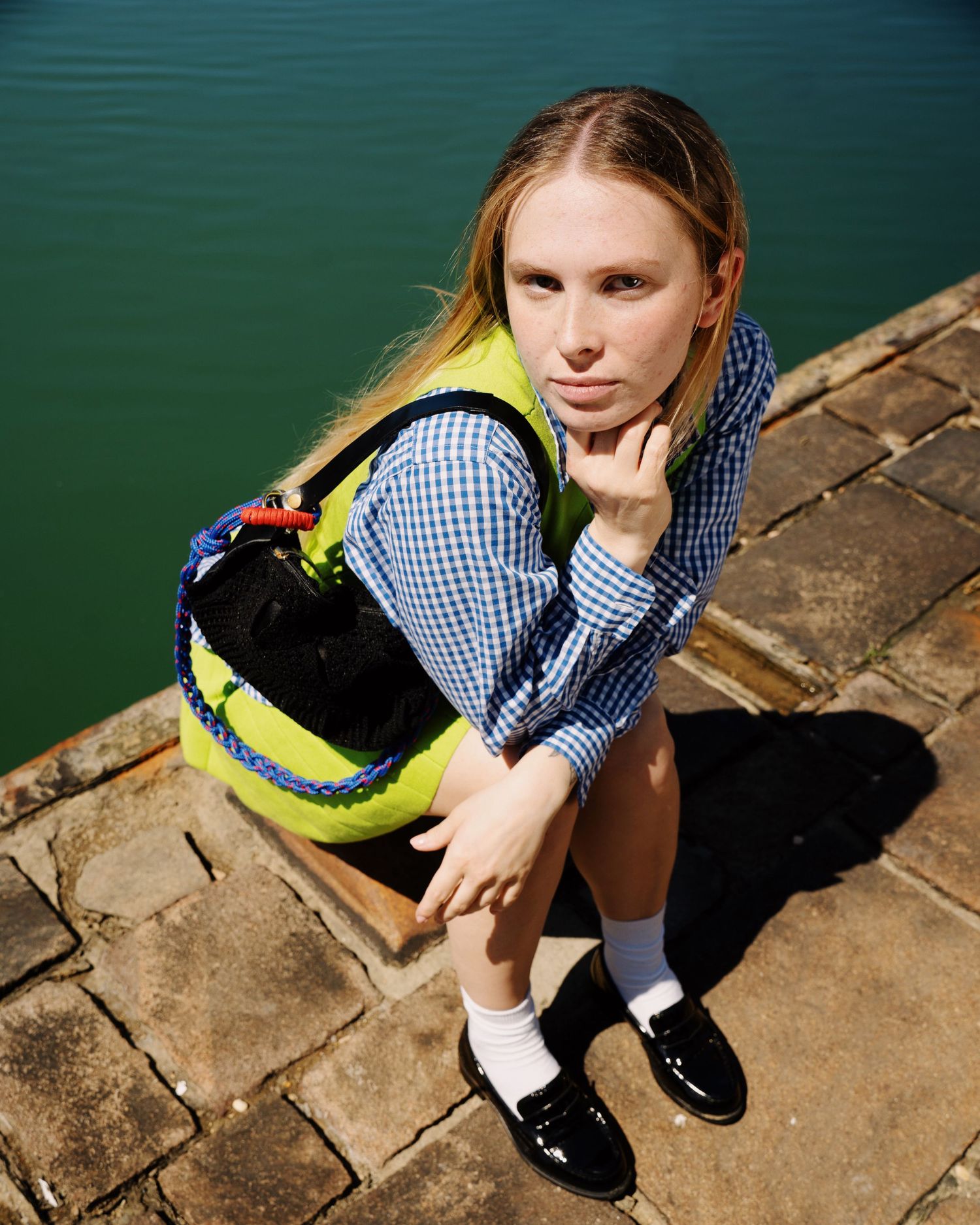 Photograph of a blond girl wearing a green shirt at the port in Rimini. Photography by studio sale.