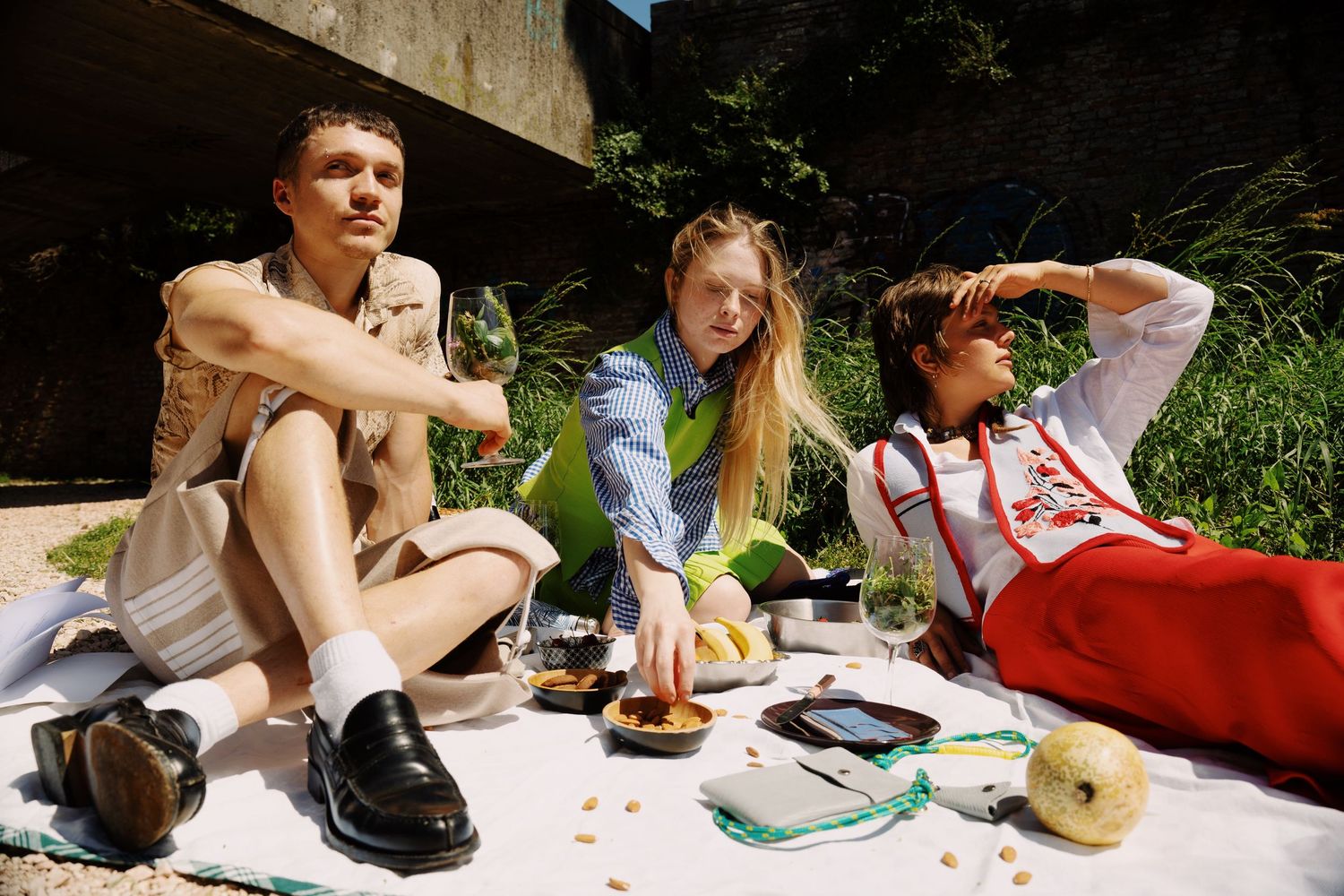 Photograph of a two girls and one guy enjoying a picnic at the port in Rimini. Photography by studio sale.