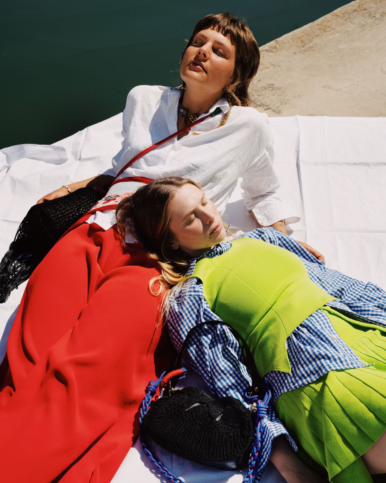Photograph of two girls laying by the port in Rimini. Photography by studio sale.