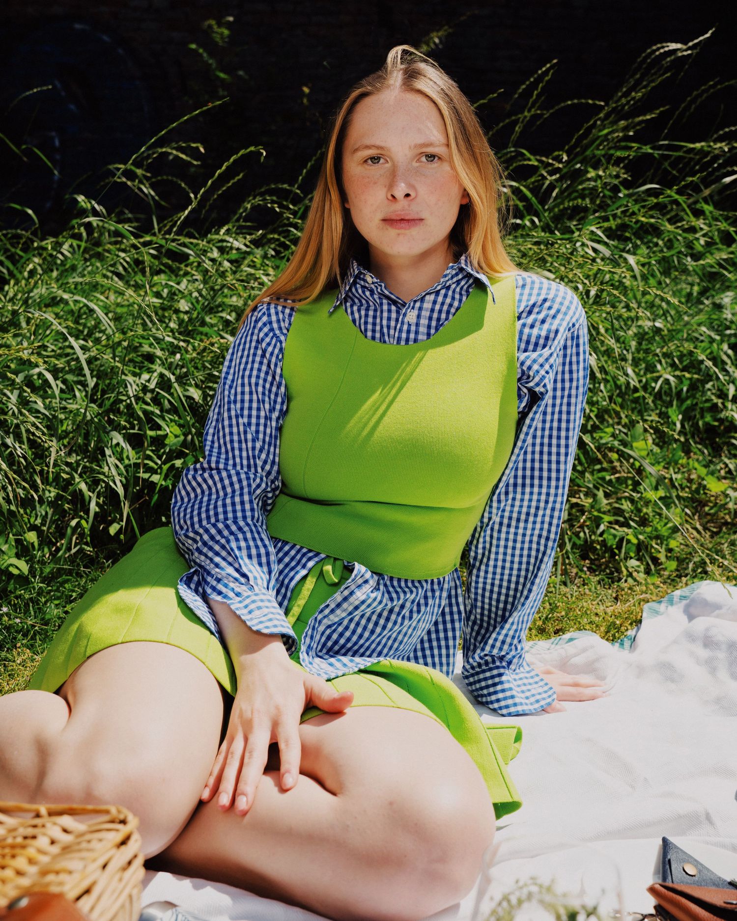 Photograph of a blond girl wearing a green shirt at a picnic. Photography by studio sale.