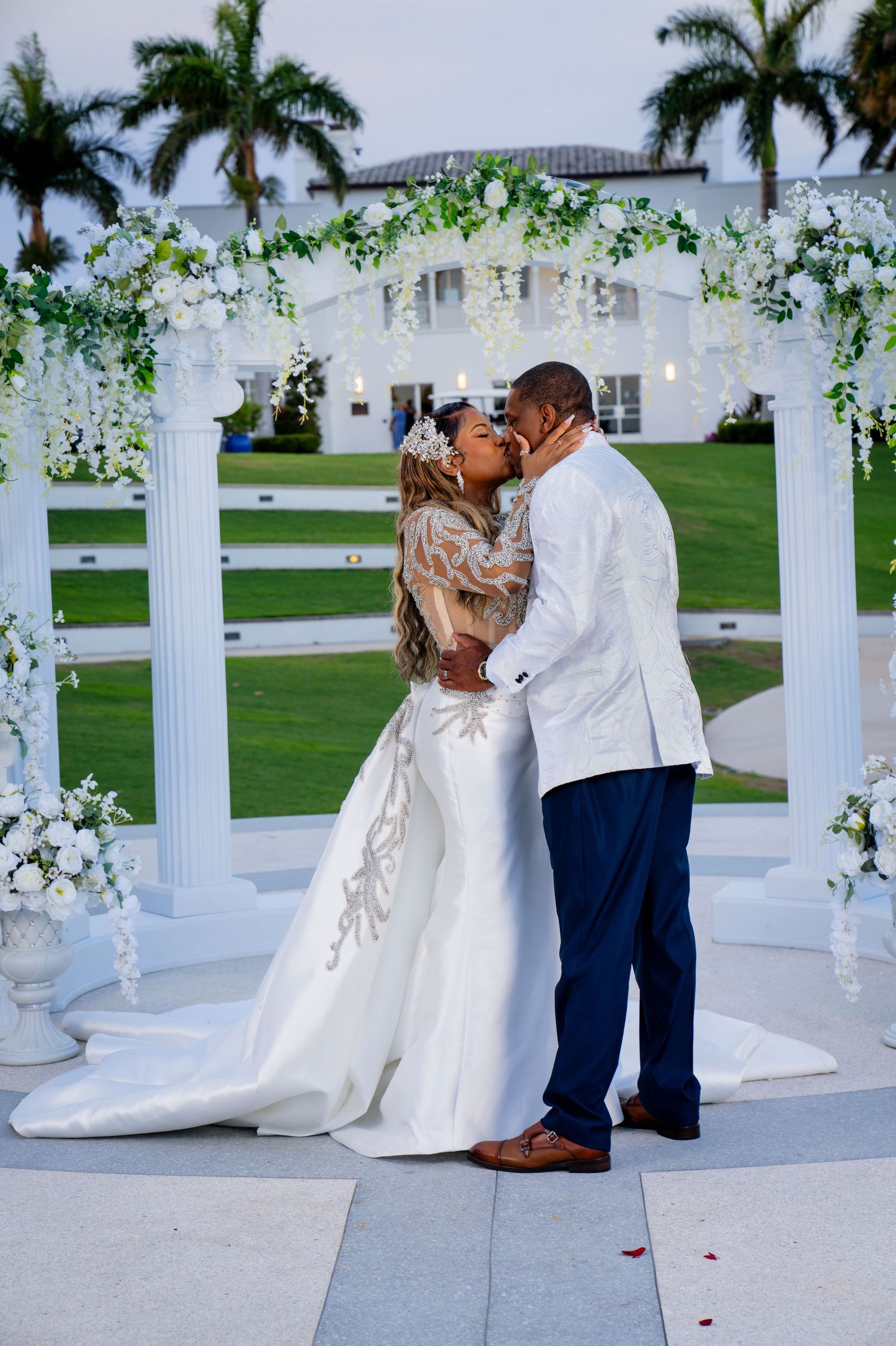 black bride and groom kiss under a flower lined archway at Tuckahoe Mansion Estate.