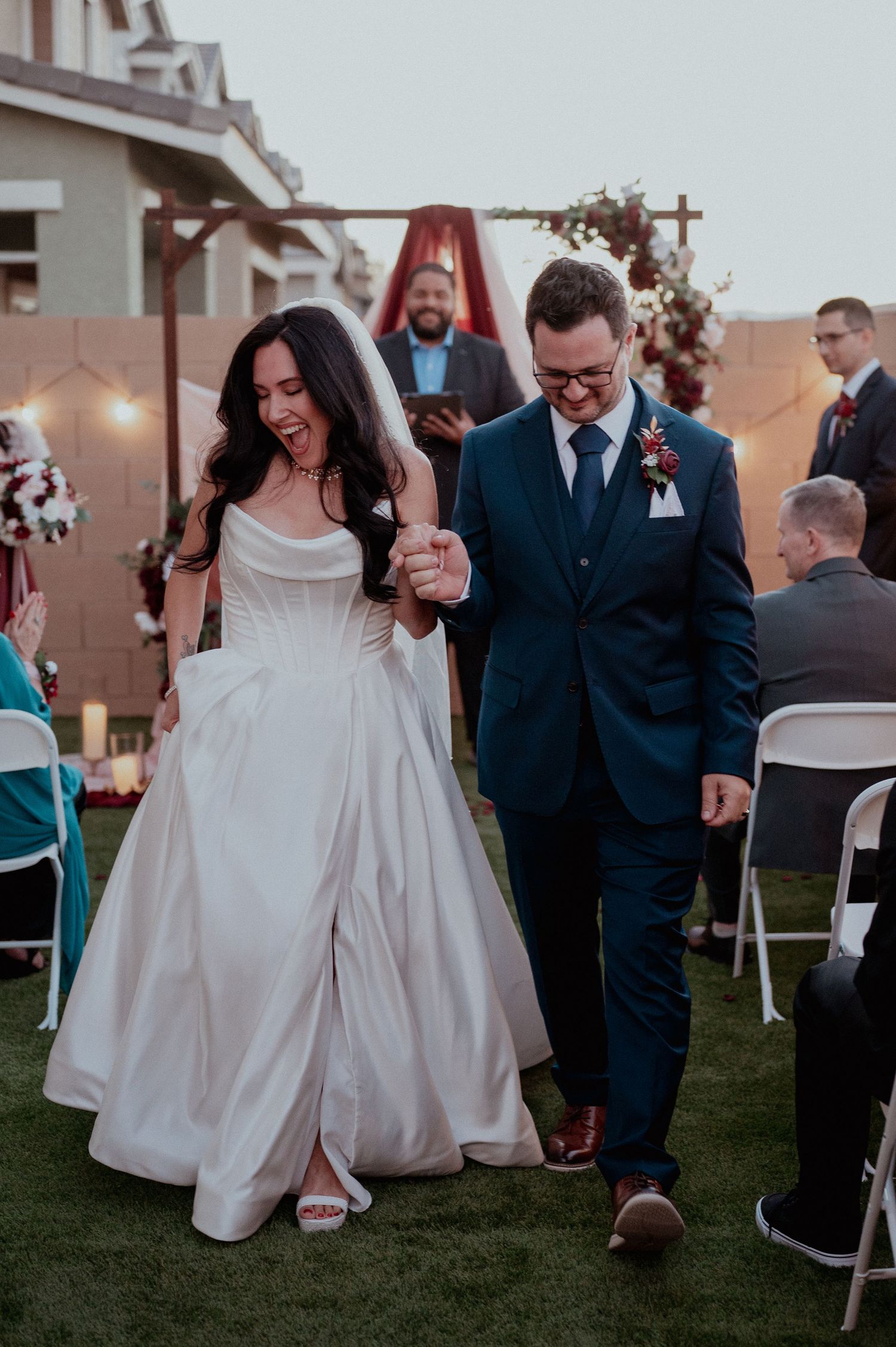 Couple celebrating down the aisle in Las Vegas backyard wedding
