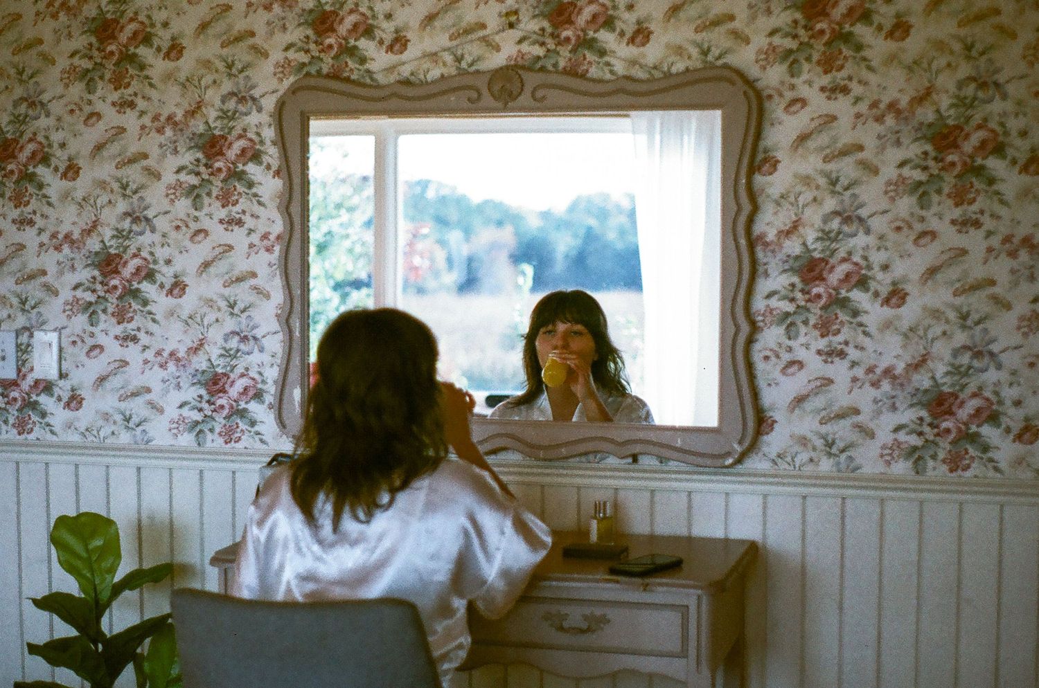 Bride getting ready on film in a vintage- inspired, romantic suite