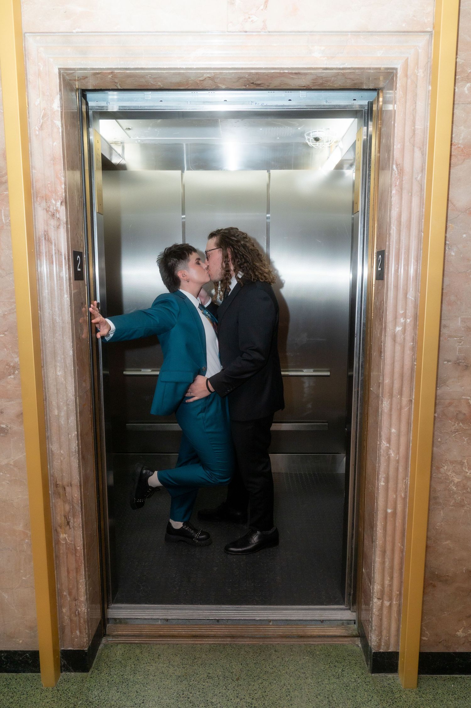newlyweds kissing in an elevator
