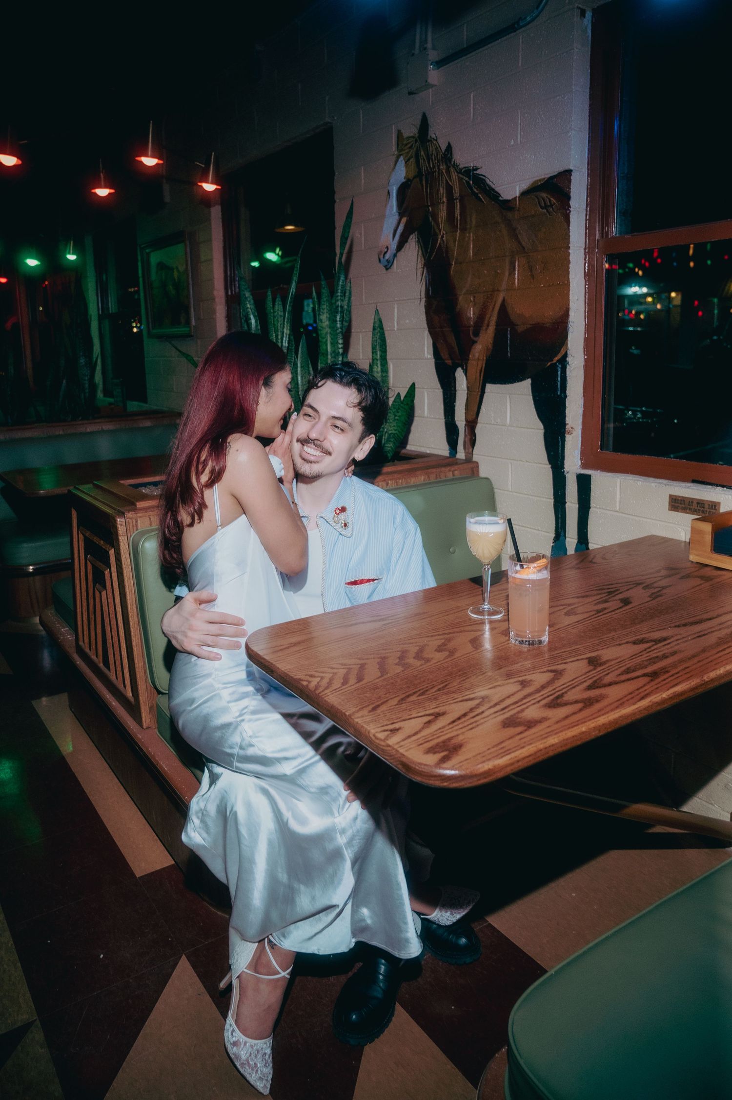Couple sharing a romantic moment at a wooden table in a kitschy vintage bar in Las Vegas