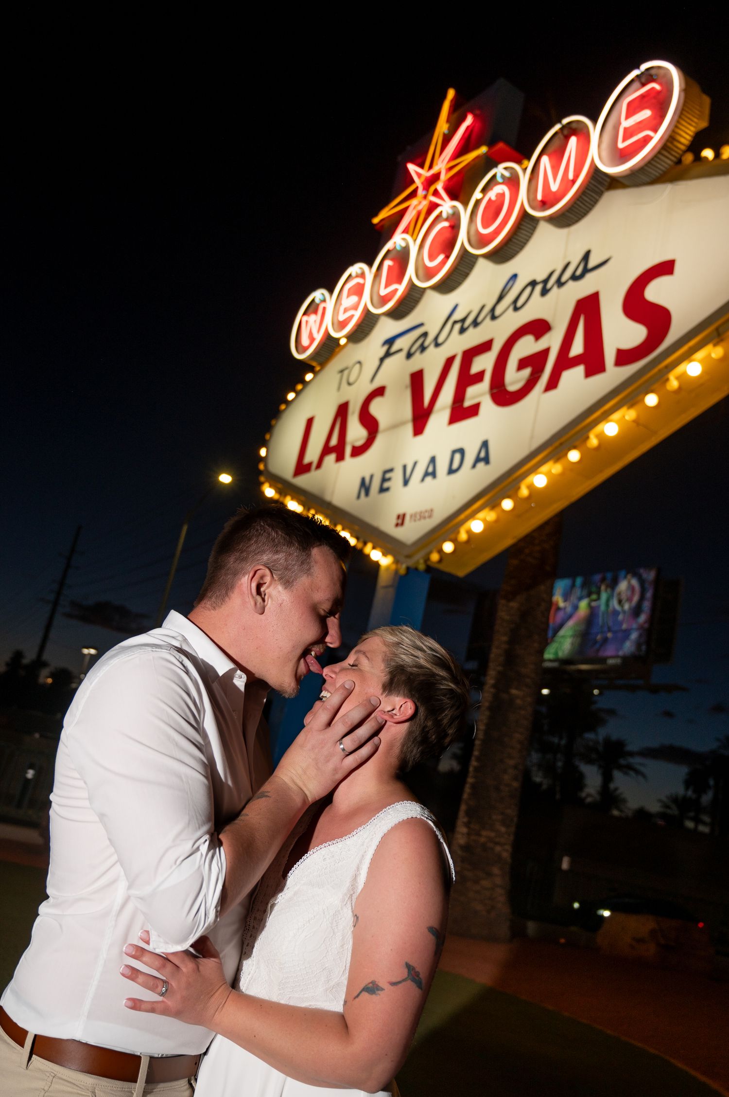 Couple being silly with eachother at vegas sign