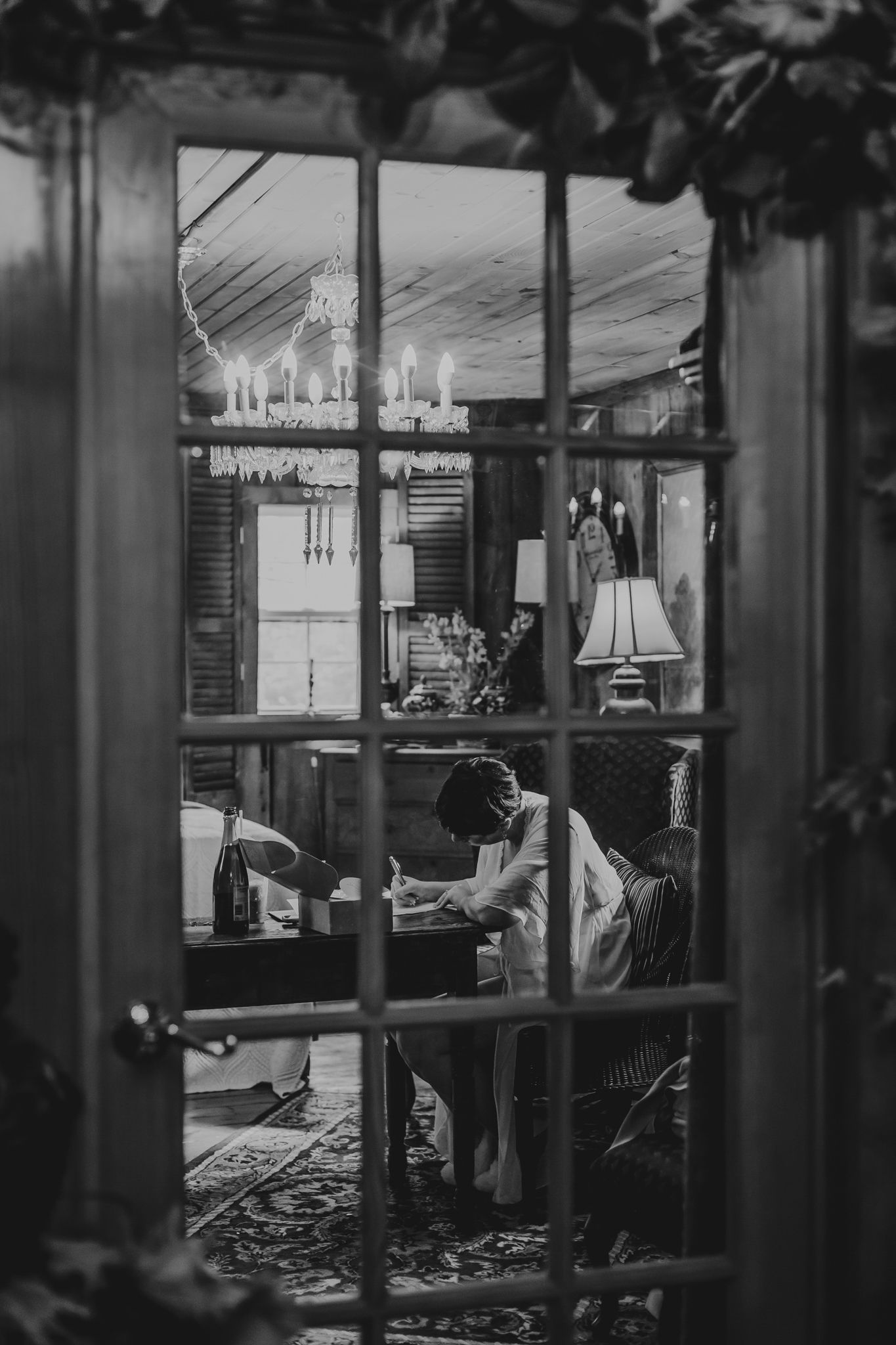 Dark interior of bar or venue with silhouettes of people seen through glass partitions.