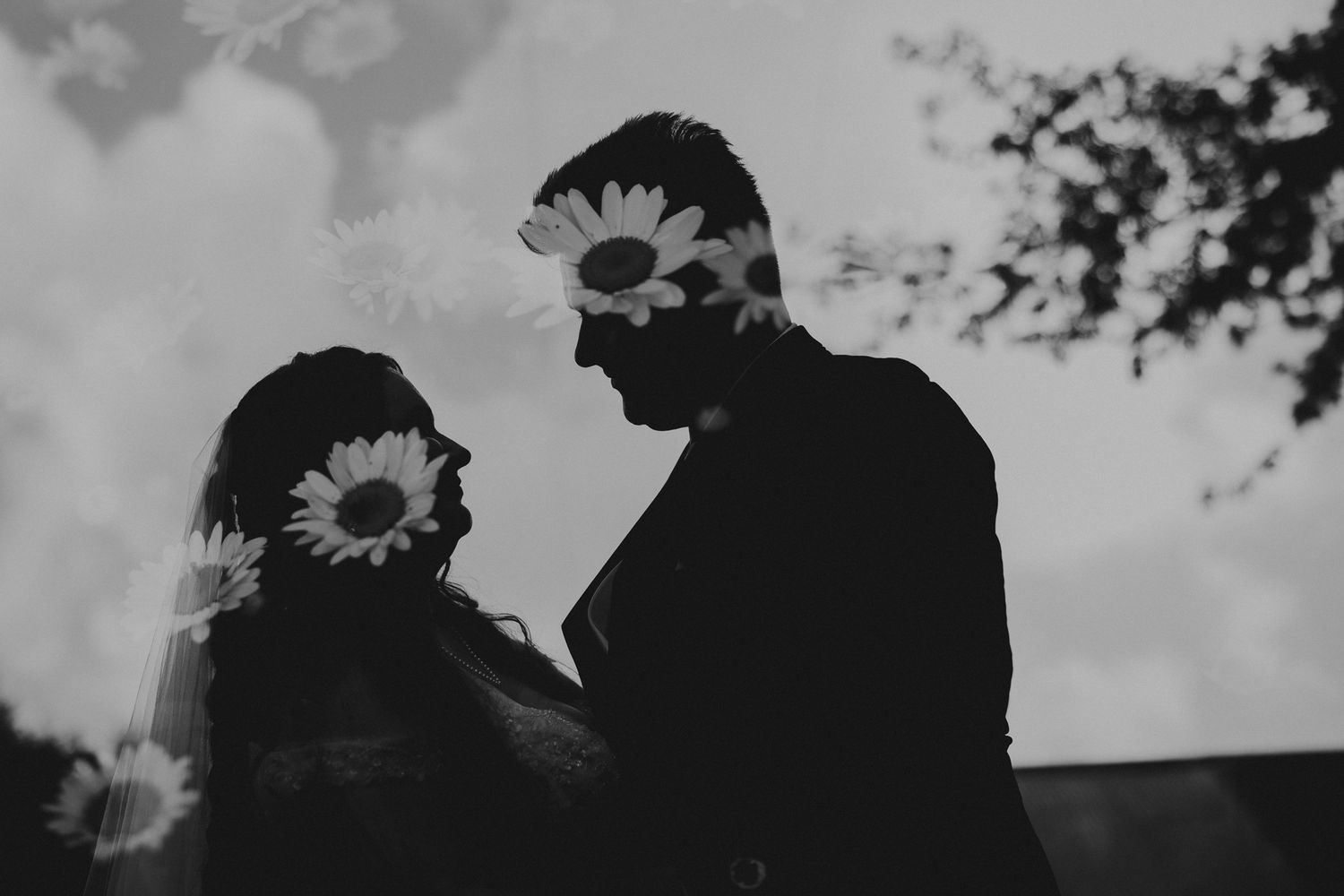 Romantic silhouettes of couple against dramatic sky at sunset.
