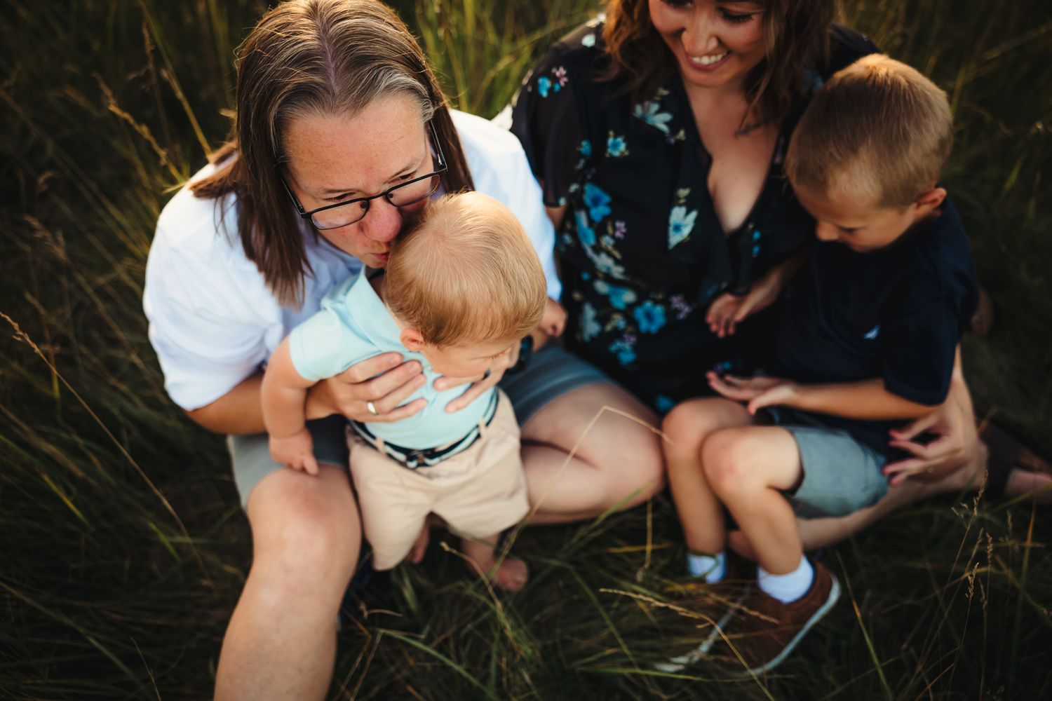 A group relaxing together in tall grass during golden hour.