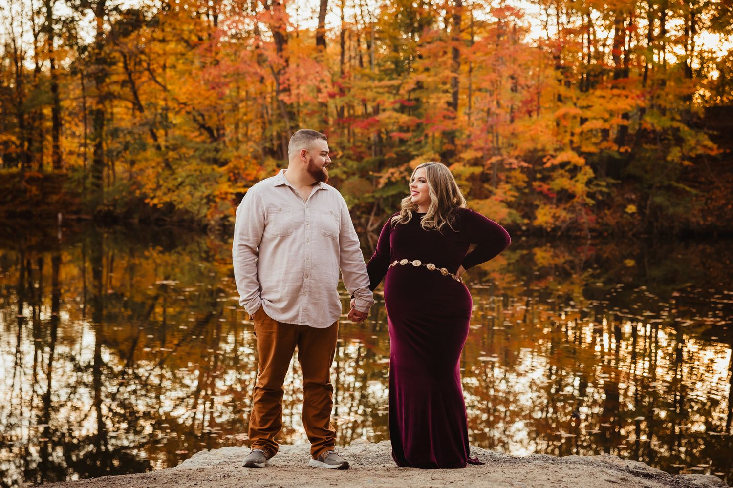 Autumn family photoshoot in a forest with orange and golden foliage.