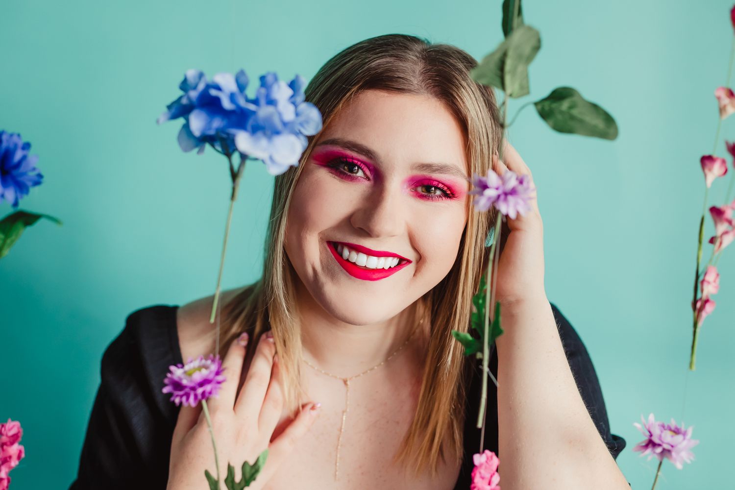 Colorful spring portrait with blue flowers against turquoise background.