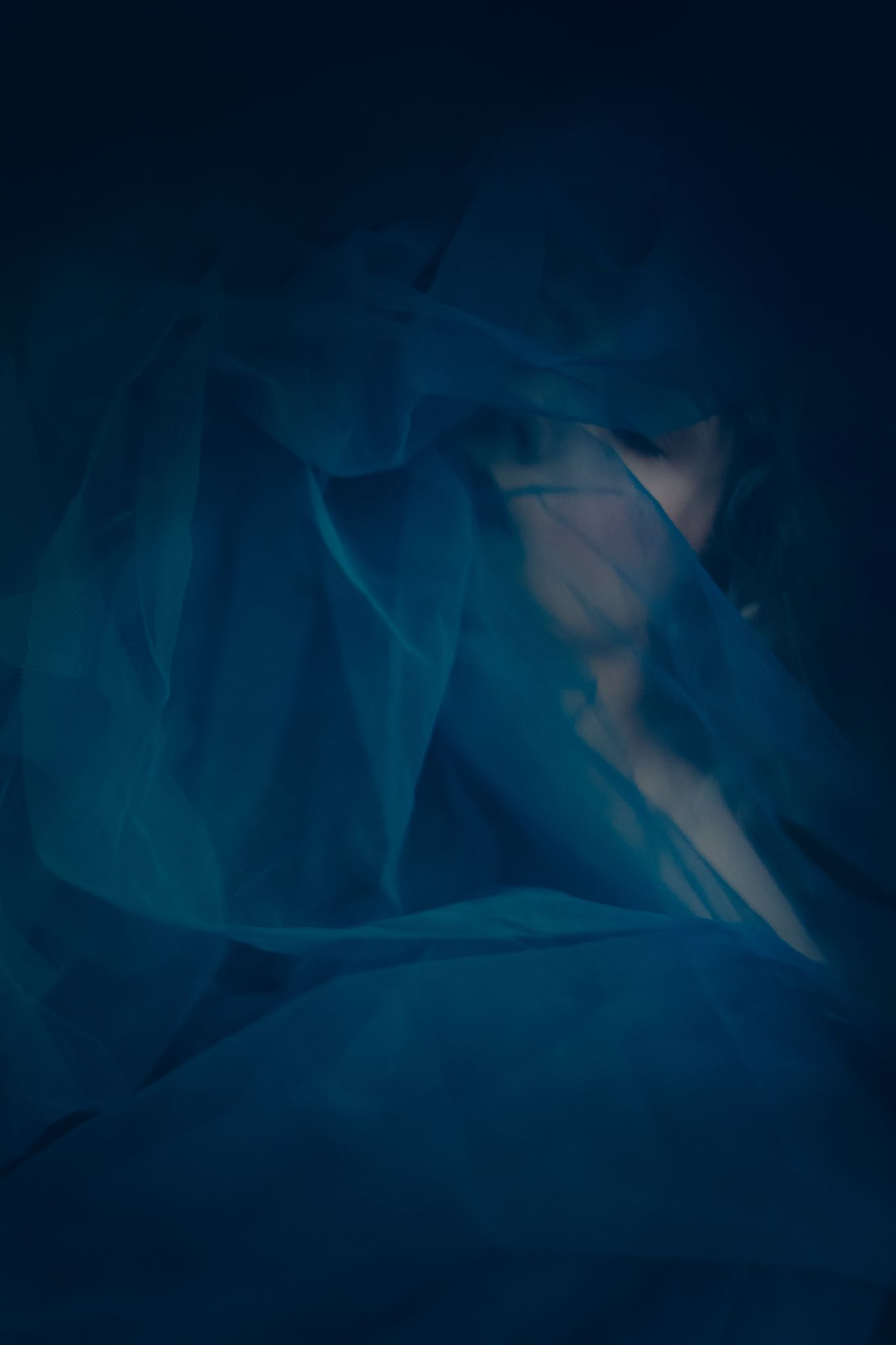 Dark abstract background with swirling blue tones and soft shadows creating a moody atmospheric effect.