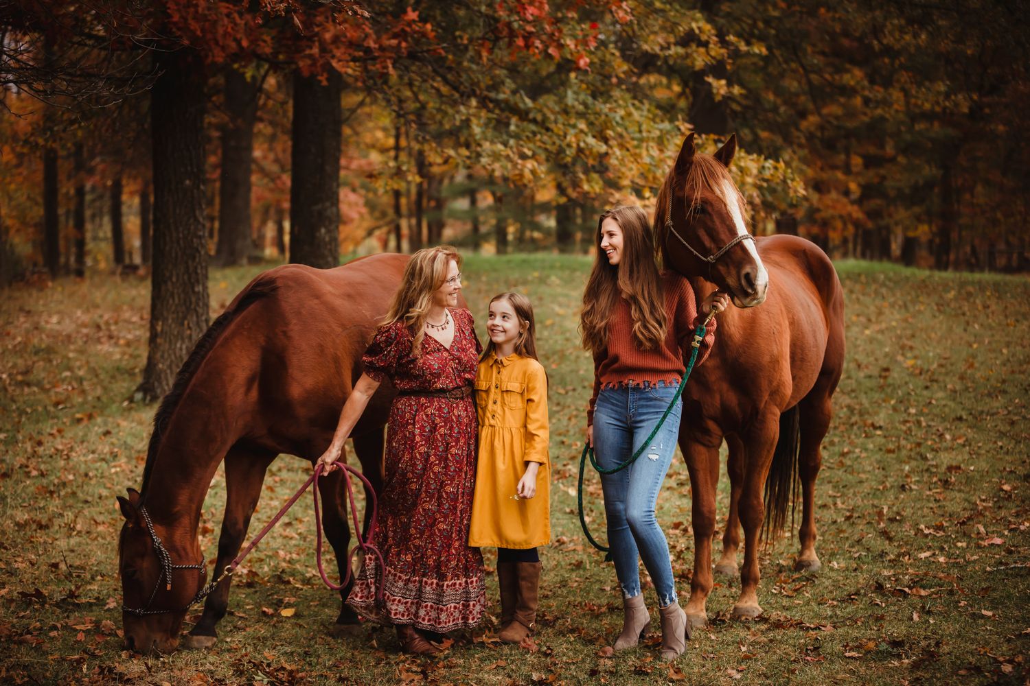 Group gathering near horses in an autumn forest setting.