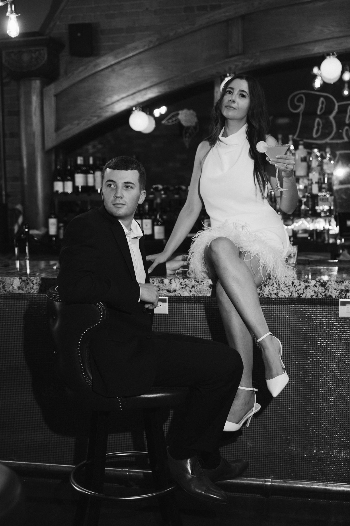 Black and white retro-styled bar scene with vintage fashion and decor.