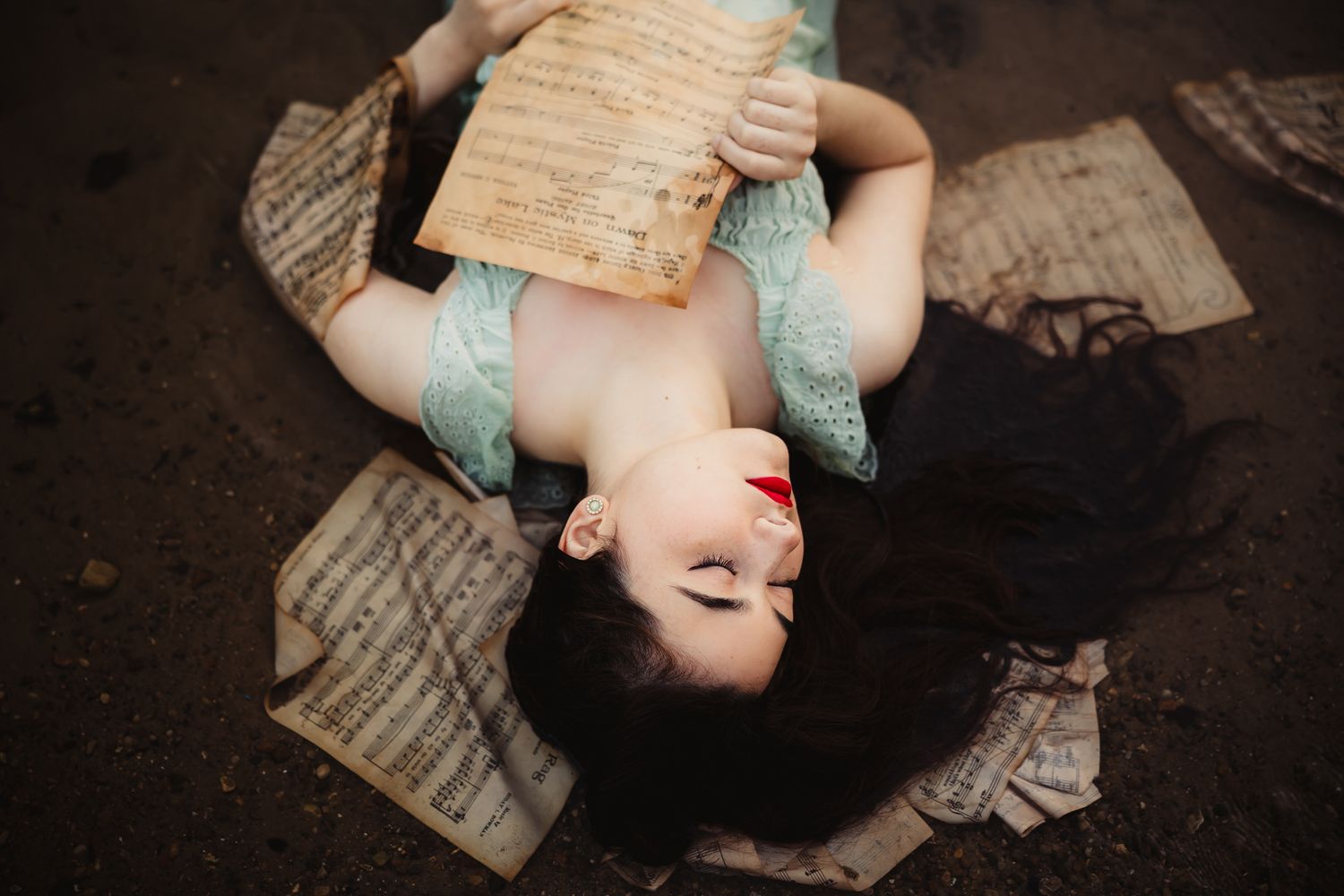 Artistic overhead shot with sheet music scattered on dark background.
