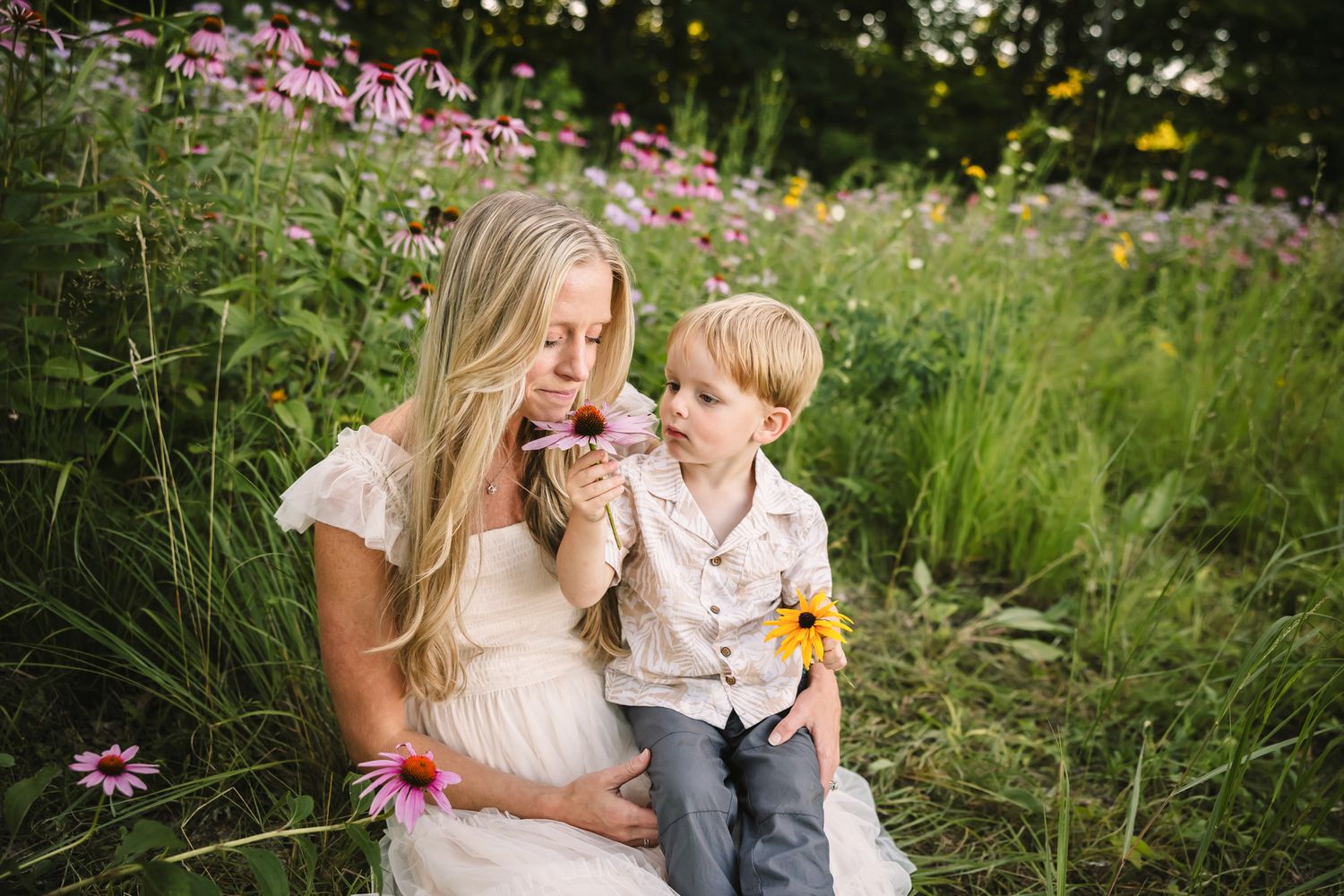 People sitting in a wildflower meadow with pink coneflowers on a summer day.